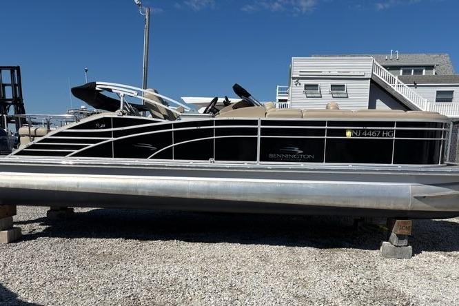 2014 Bennington 2575 RCW pontoon boat on dry dock, side view.