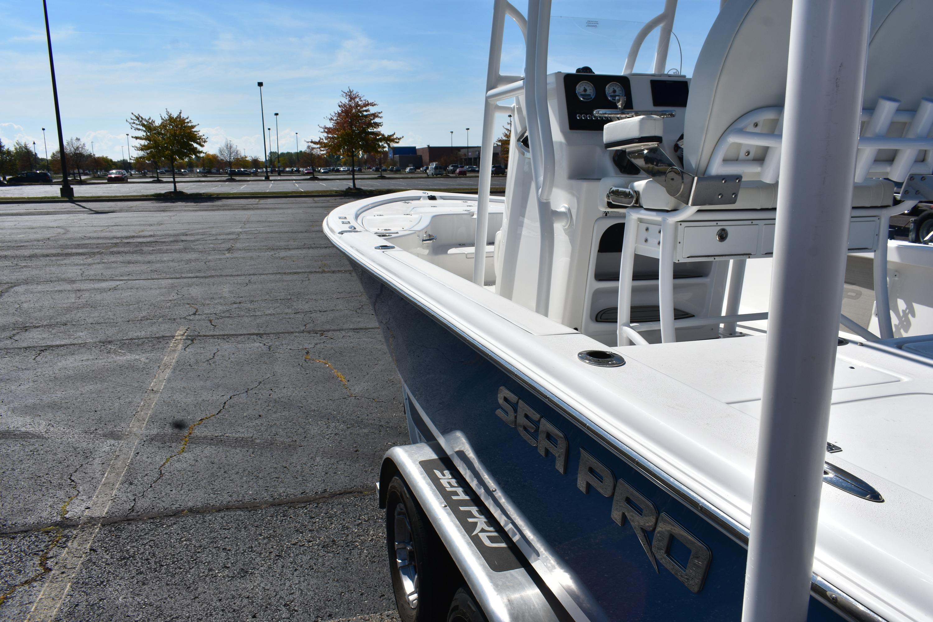 2025 Sea Pro 250 Bay boat parked in an empty lot under clear skies.