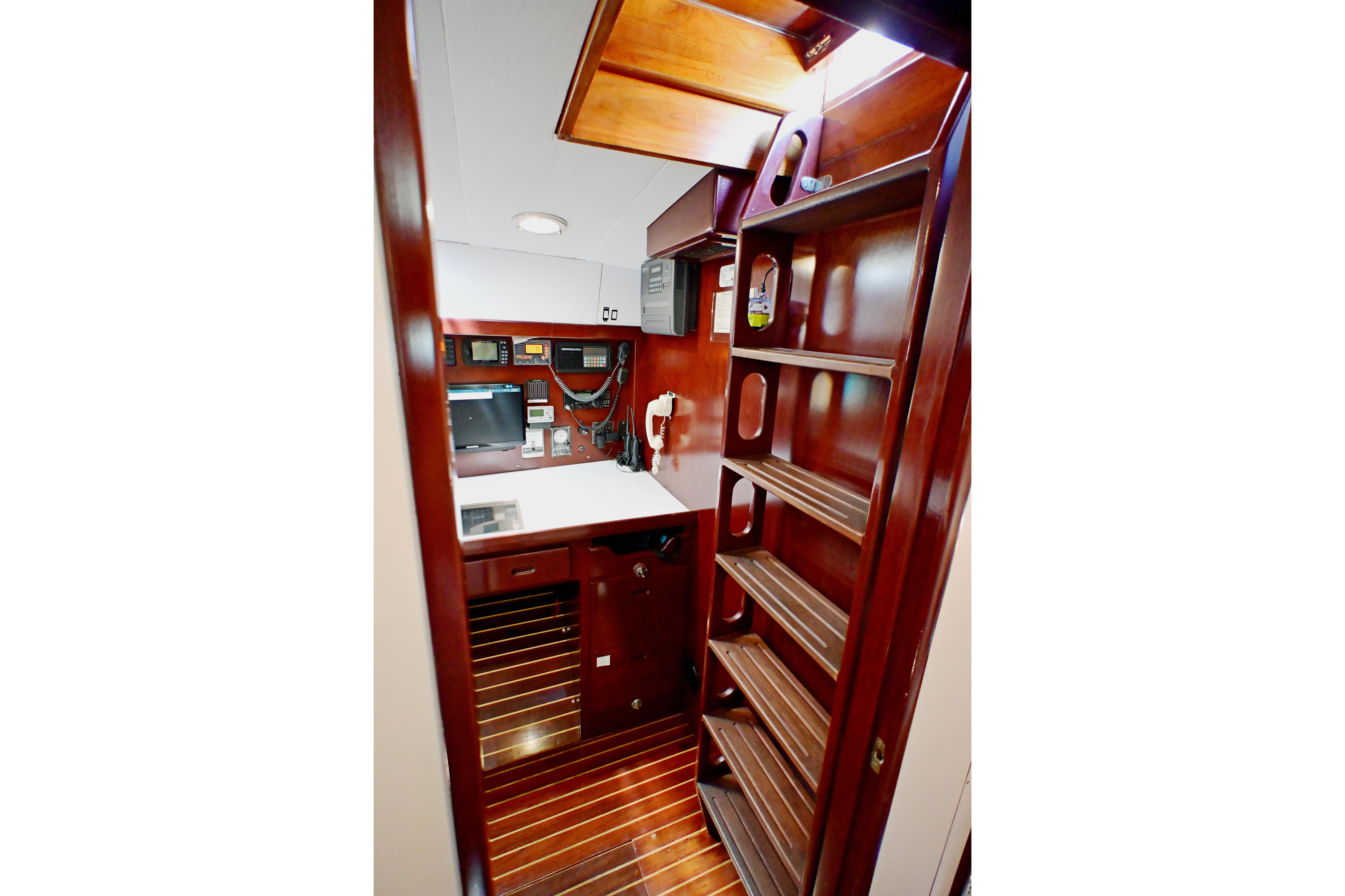 Interior of 1968 Abeking & Rasmussen Tripp 74 yacht with wooden cabinetry and navigation equipment.