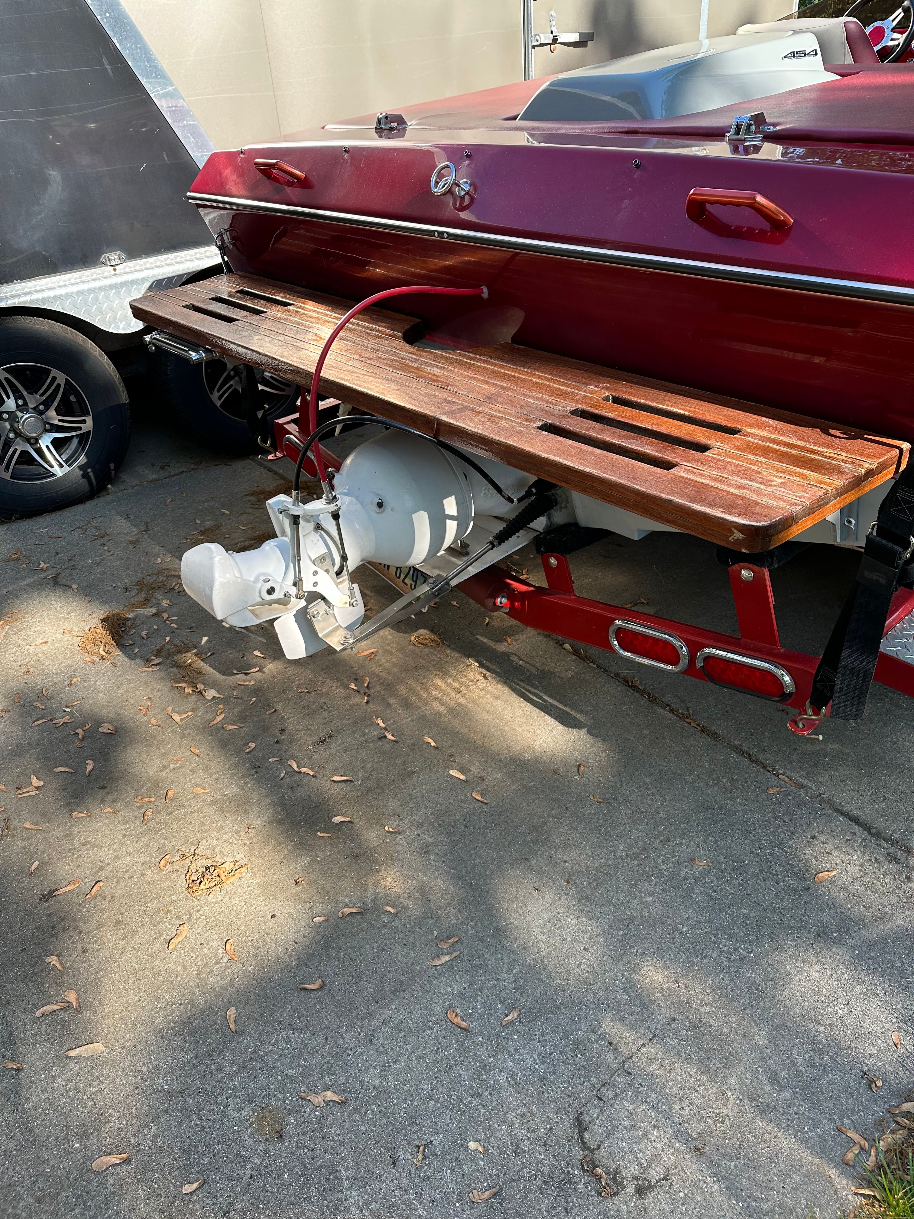 Red Custom Jet Boat 22' from 1989 with wooden platform.