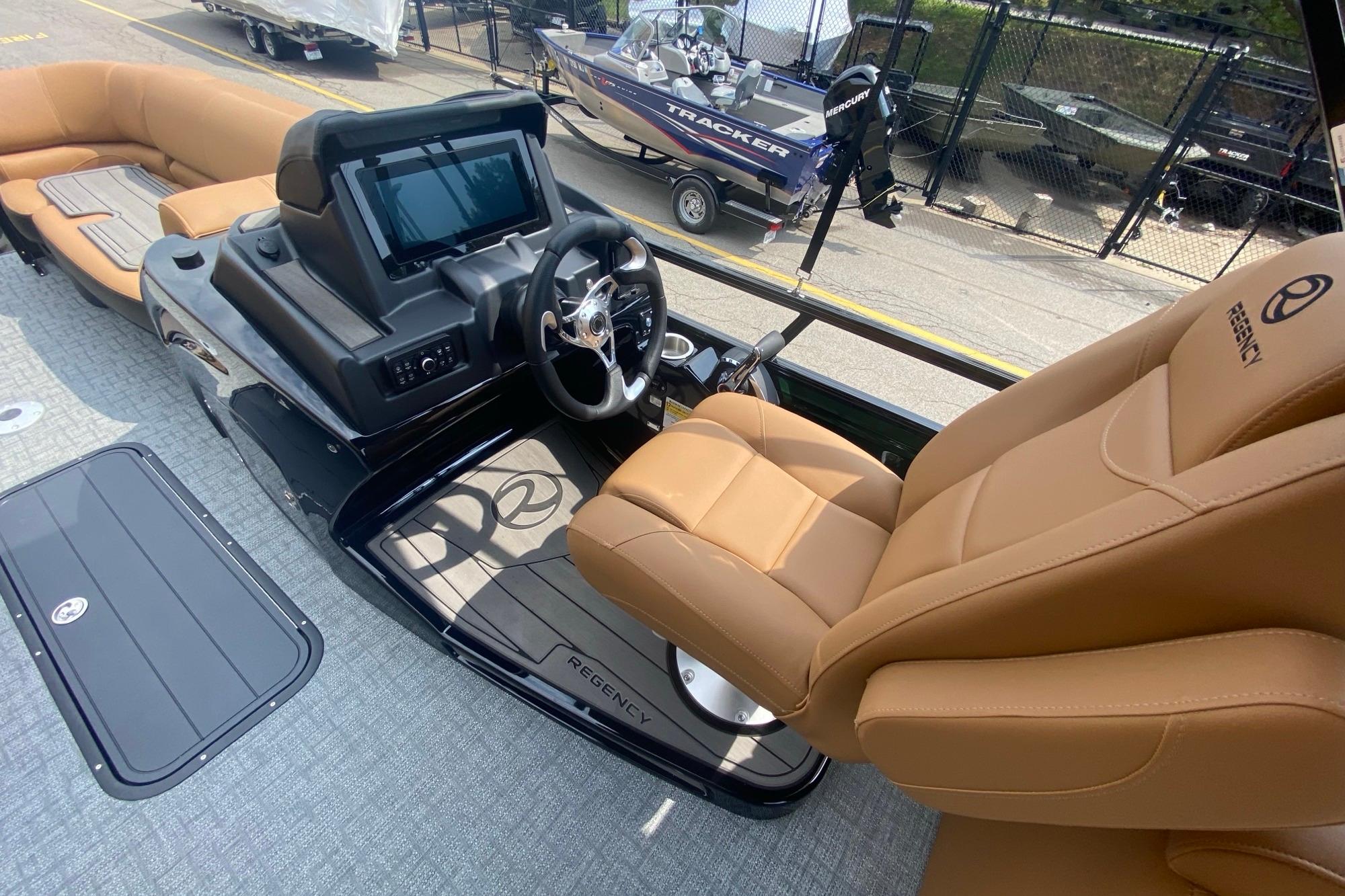 Luxurious 2026 Regency 230 DL boat interior with tan seating and modern dashboard.