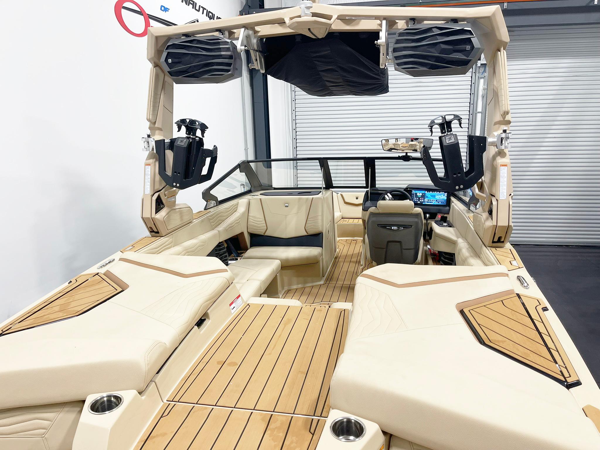 2025 Nautique Super Air Nautique G25 interior with beige seating and advanced dashboard.