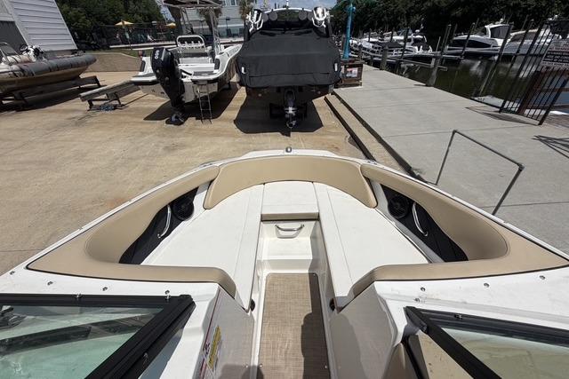 2018 Sea Ray SPX 190 boat interior with beige seating, docked near other boats.