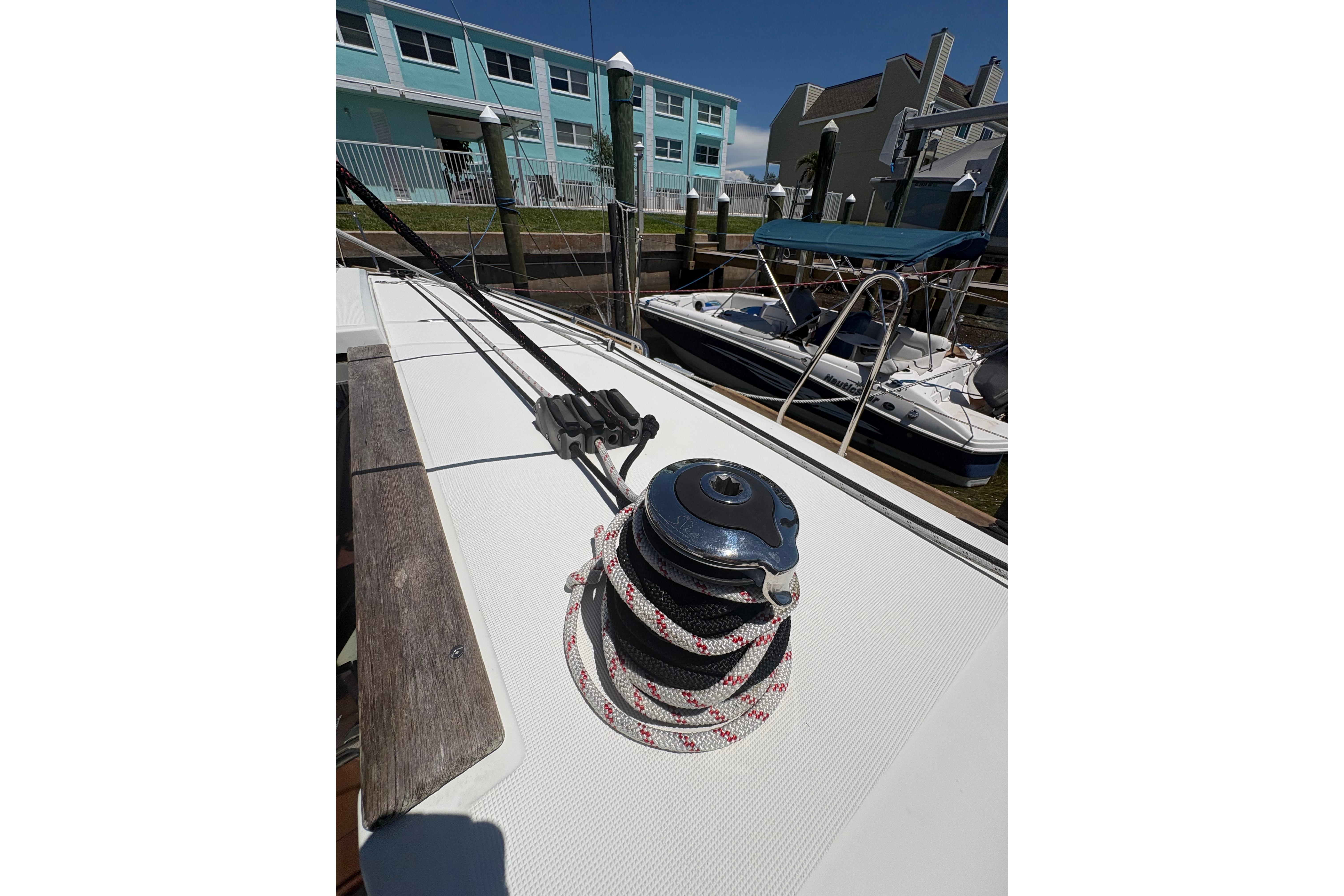 2021 Jeanneau Sun Odyssey 349 sailboat deck with winch and ropes in marina.