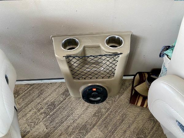 Cup holders and speaker on the floor of a boat.