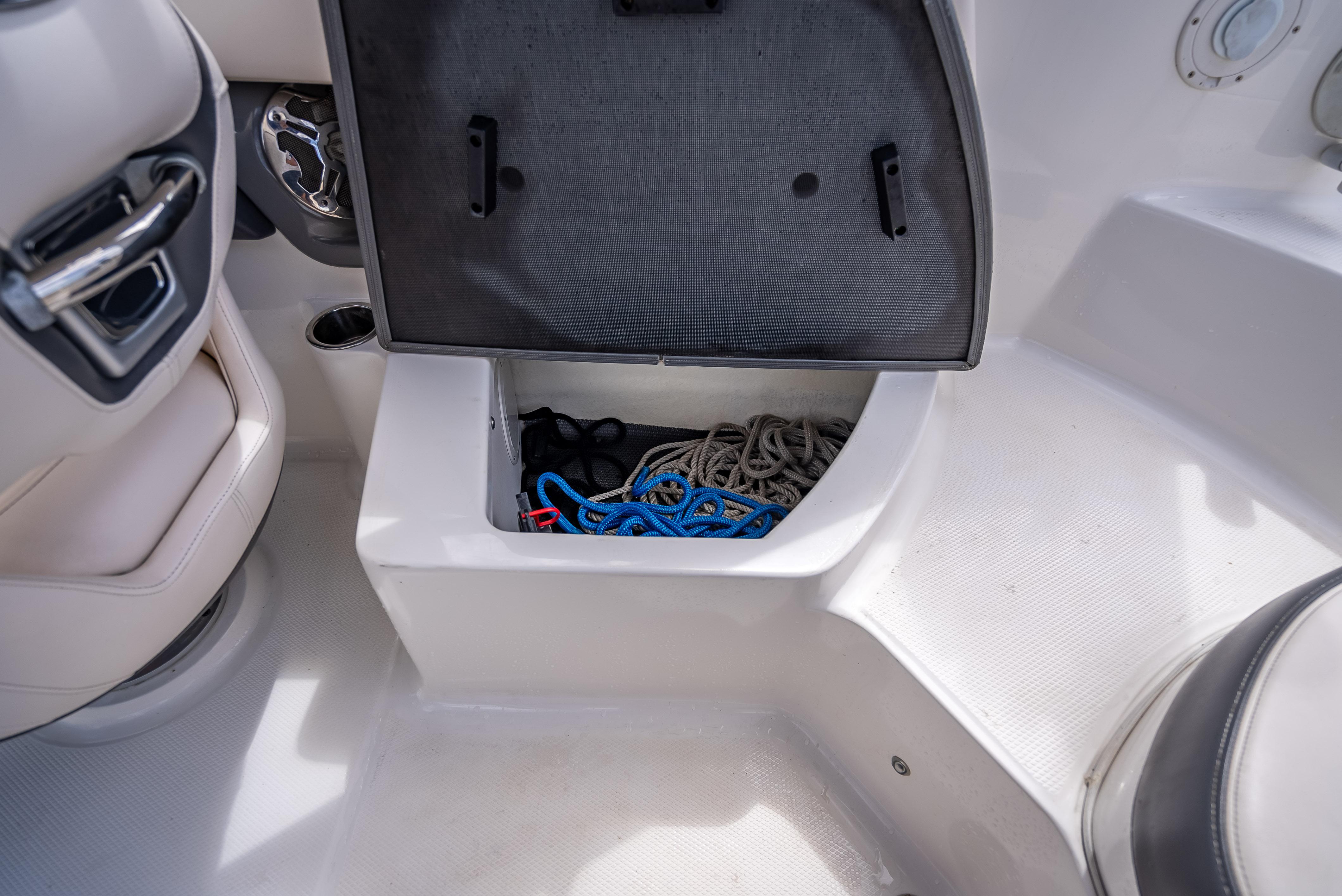 Open storage compartment in 2017 Chaparral 227 SSX boat with ropes and accessories.