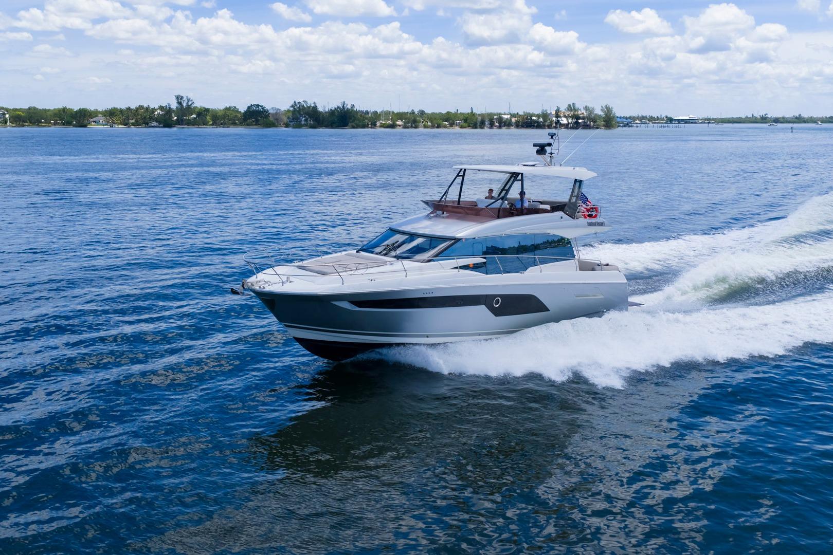 Luxury 2022 Prestige 520 yacht cruising on open water under a clear sky.