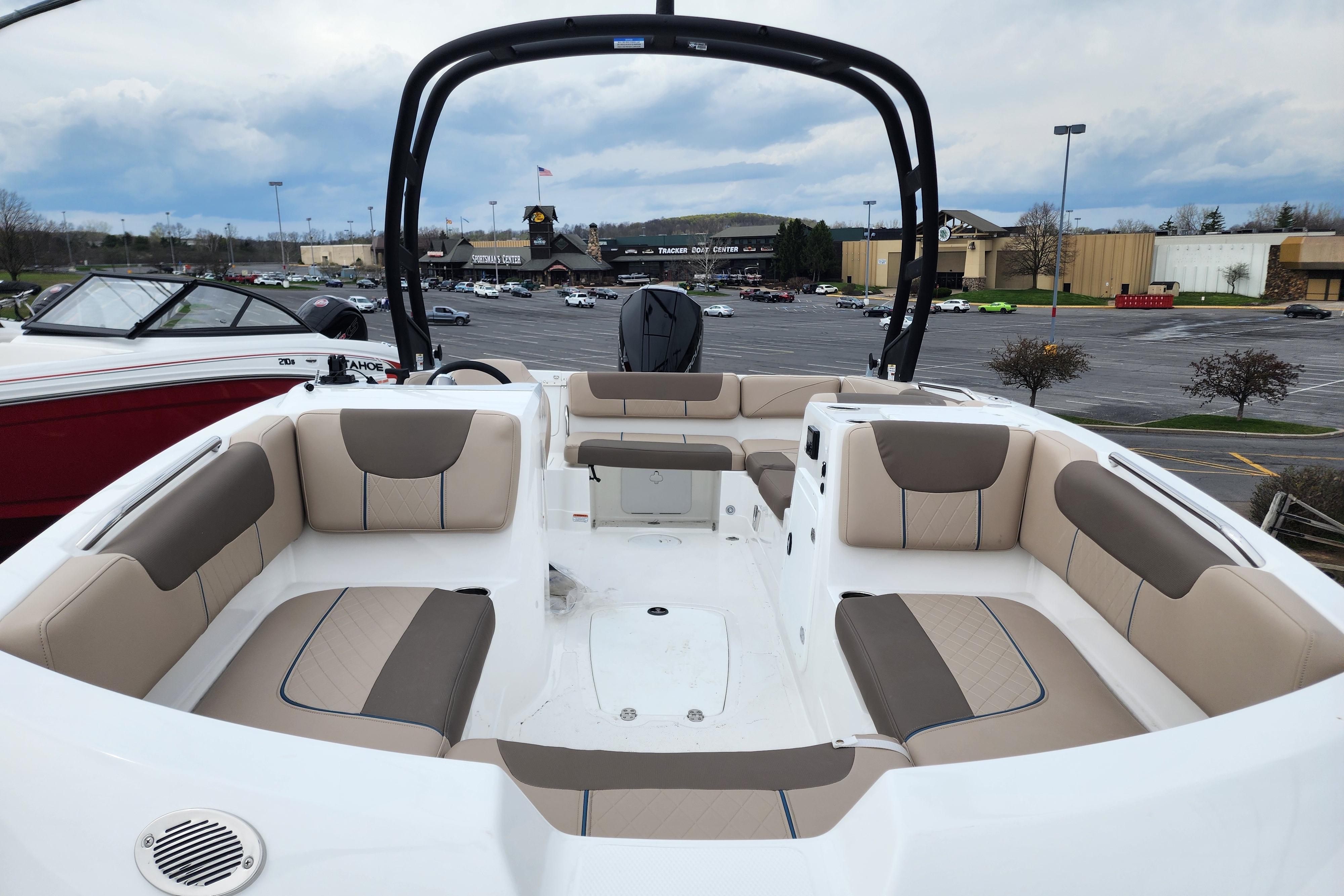 2026 Tahoe 2150 boat with spacious seating, parked outdoors near a shopping center.