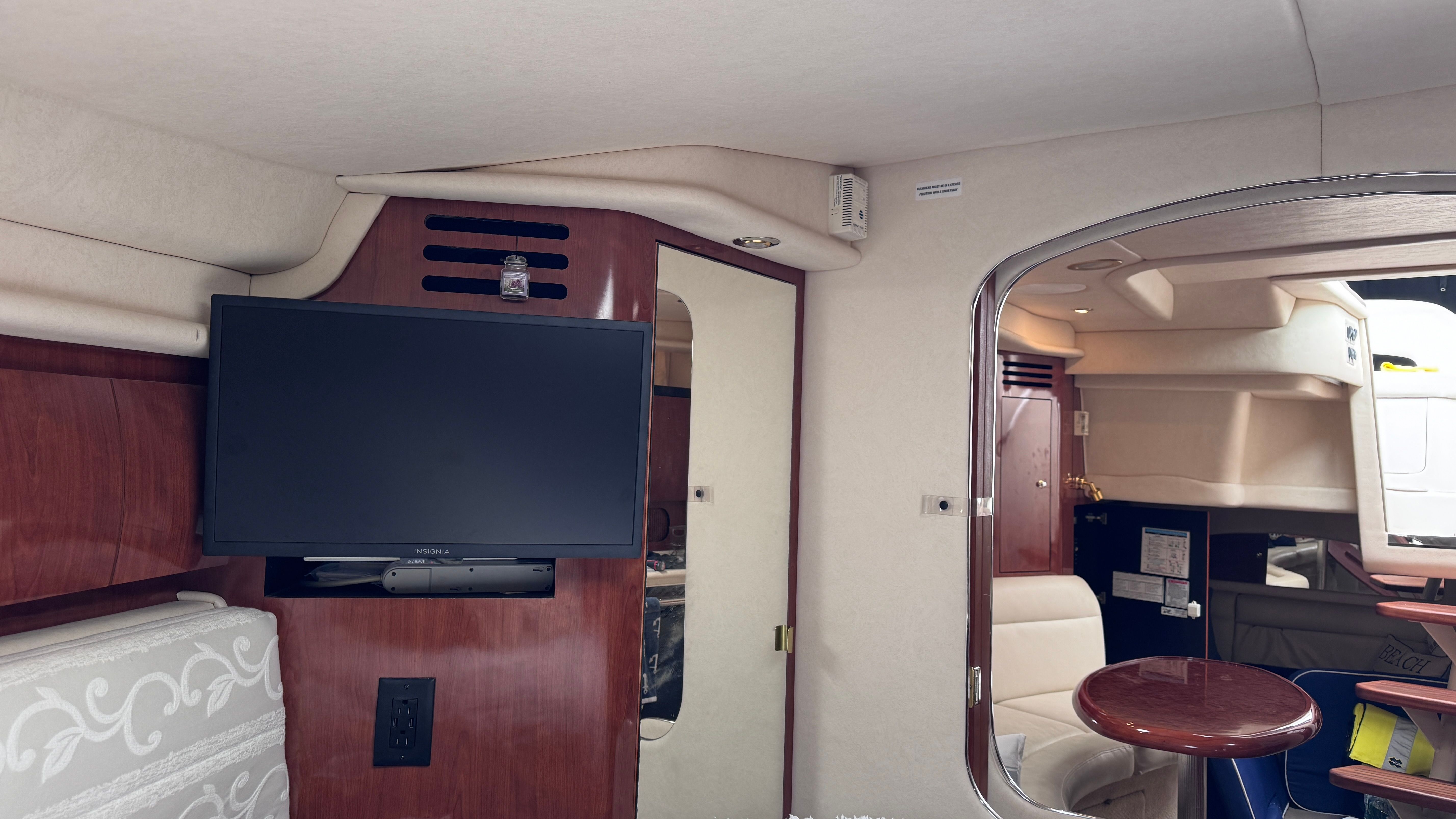 Interior of a 2003 Sea Ray 360 Sundancer with a TV and seating area.