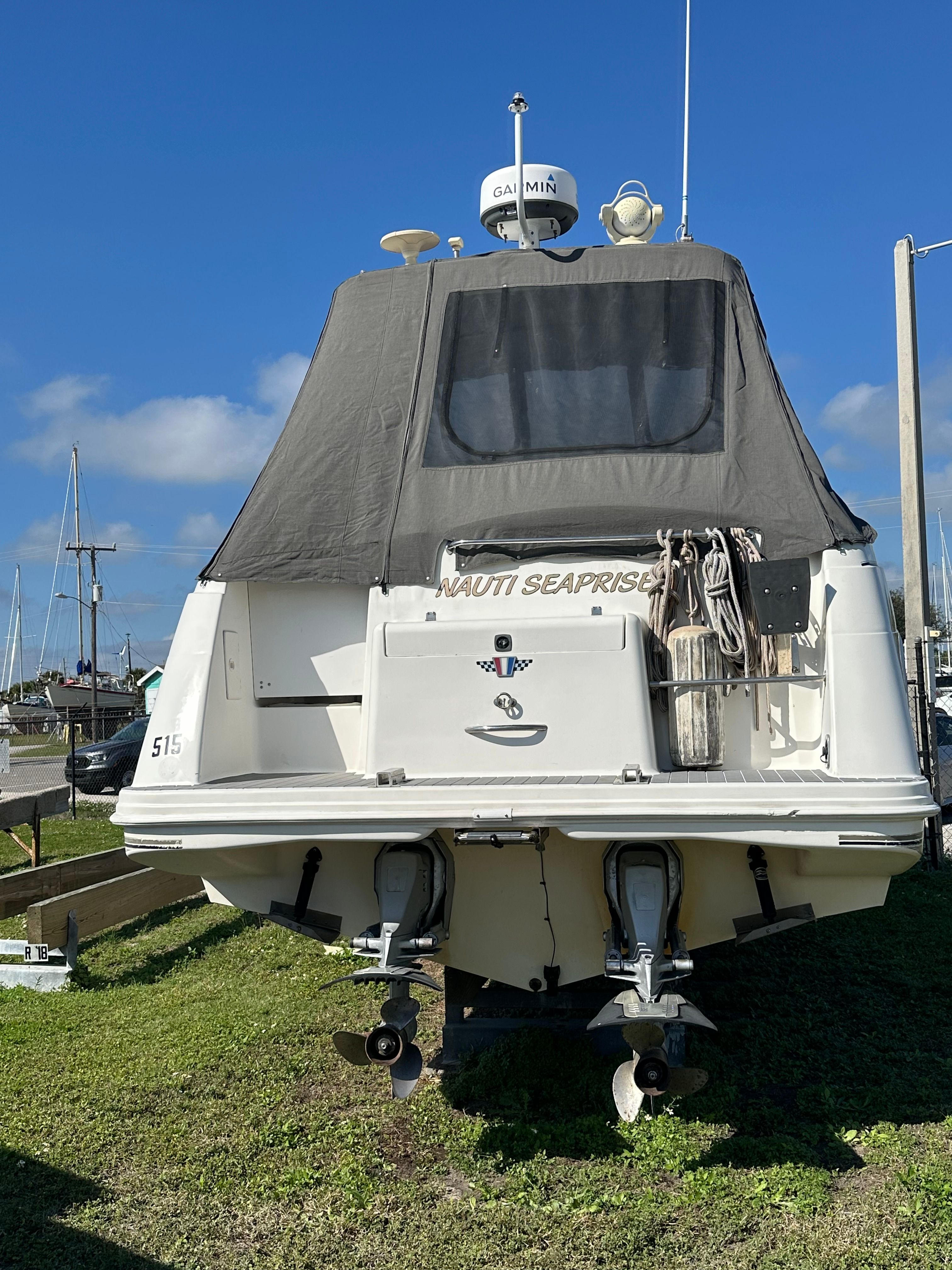 Rear view of a 1999 Wellcraft 3000 Matrinique boat in harbor.