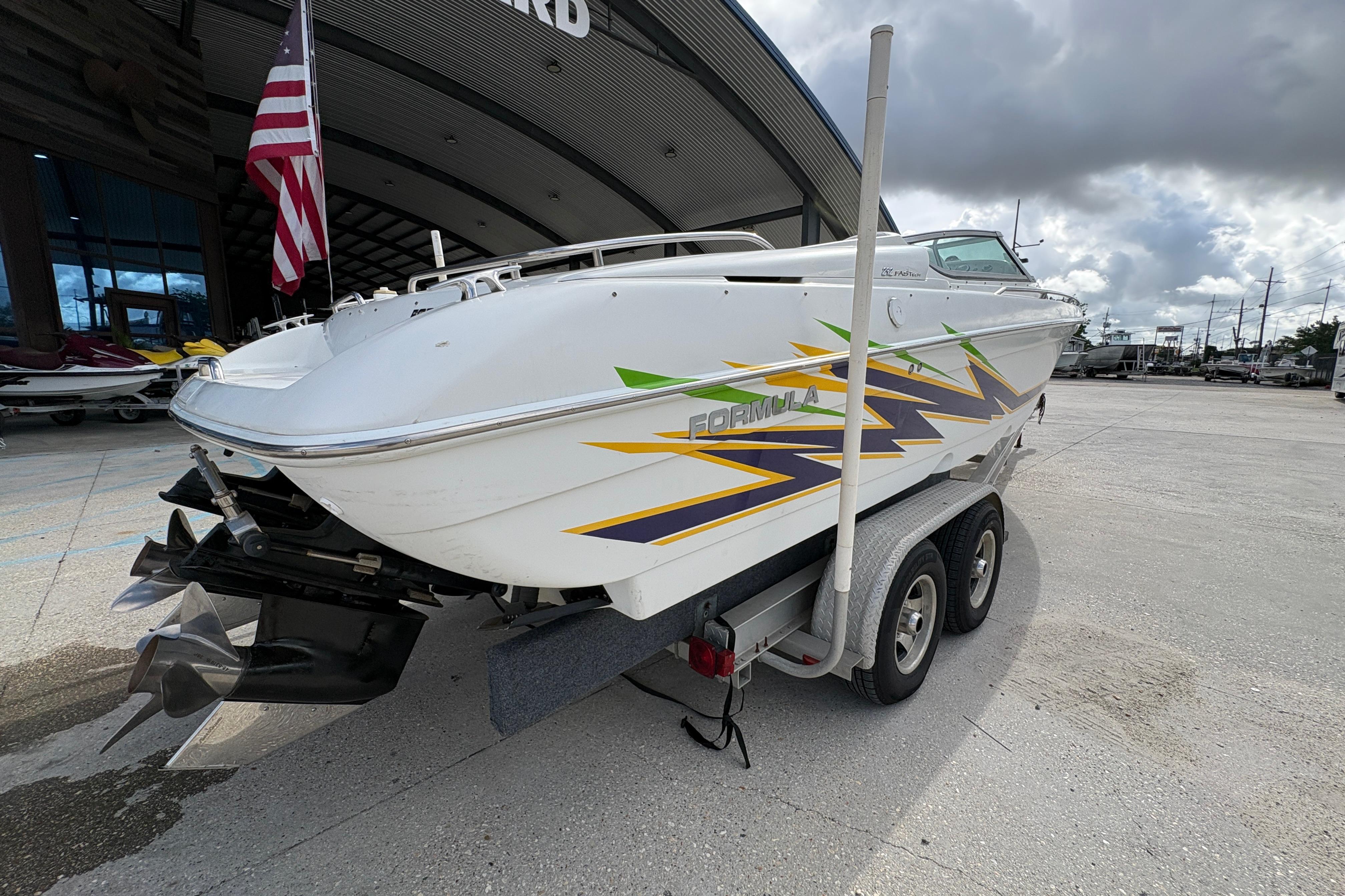 2002 Formula 292 FASTech boat on trailer, featuring vibrant graphics and dual propellers.