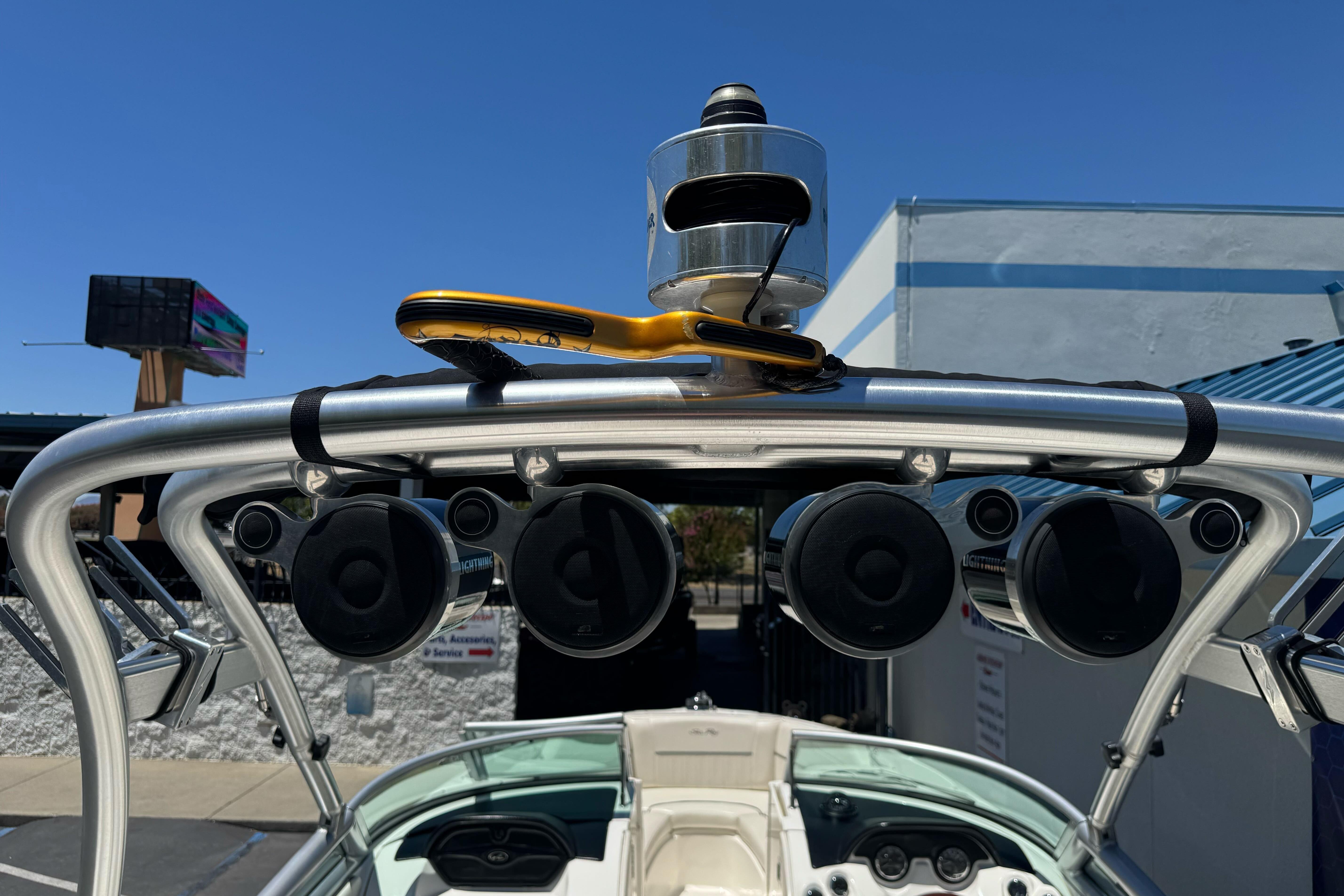2007 Sea Ray SLX 250 boat with mounted speakers and wakeboard tower under clear blue sky.