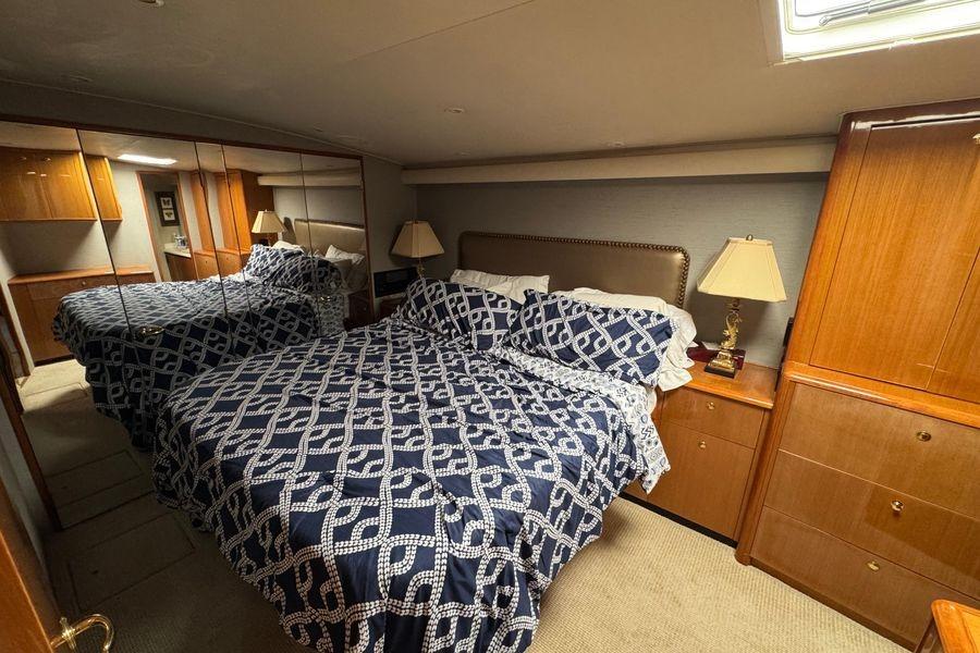 Luxurious bedroom interior of 2002 Viking 61 Enclosed Bridge yacht with mirrored closet.