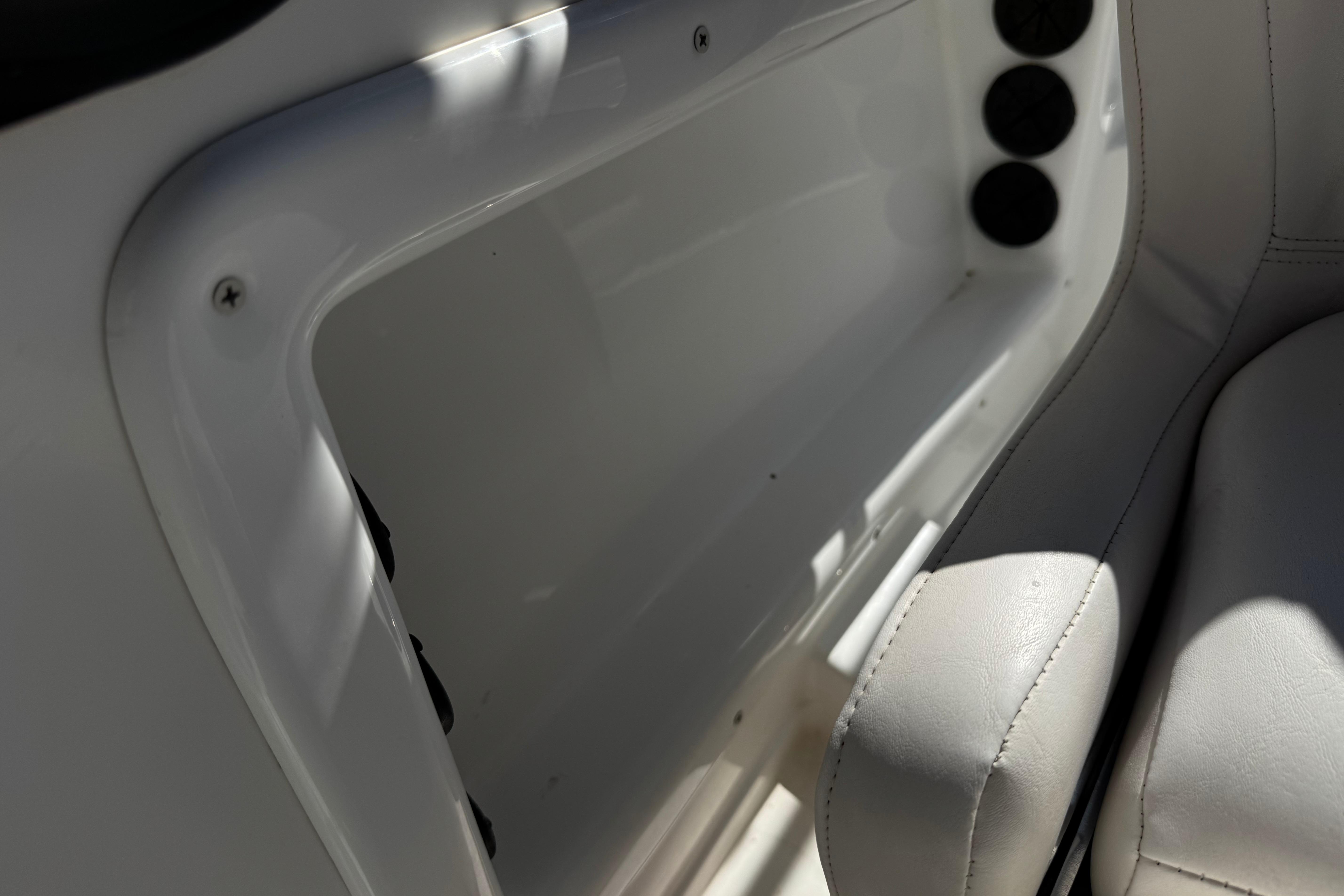 Interior of a 2019 Tahoe 2150 boat, featuring white seating and panel details.