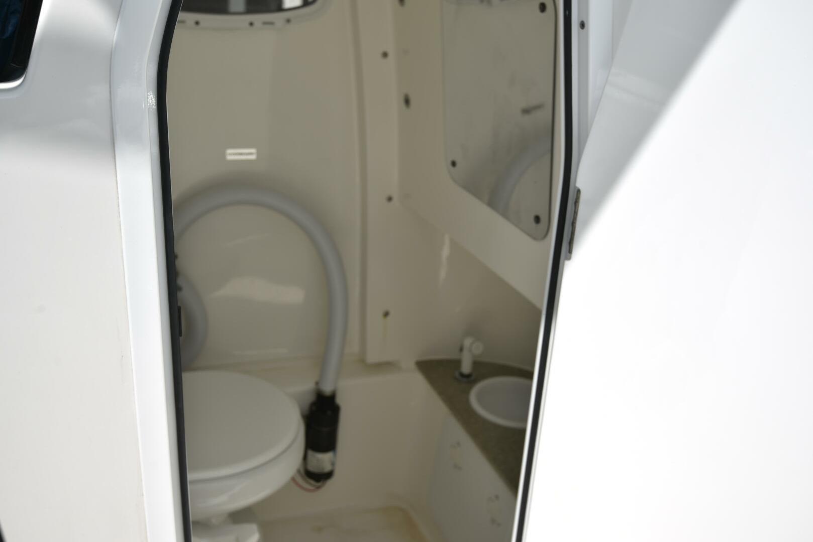 2023 Sea Pro 239 Deep V CC boat interior with compact marine toilet and sink.