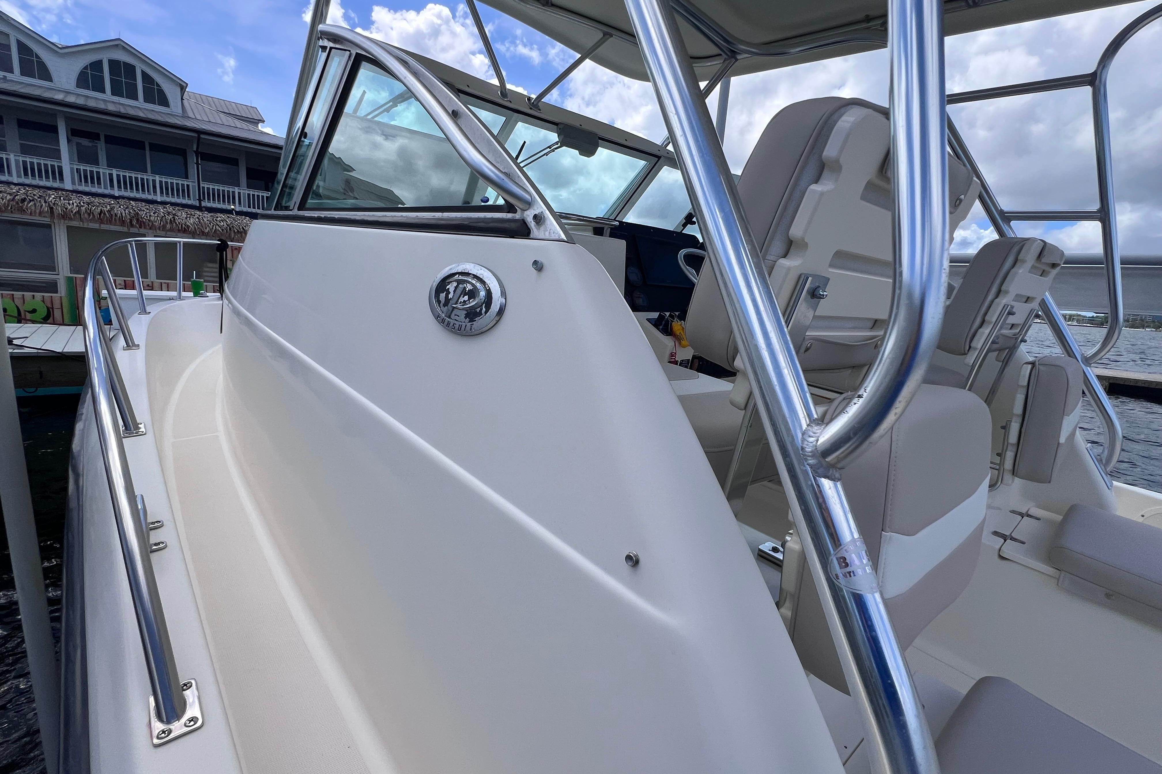 2004 Pursuit 2870 Walkaround boat with sleek design, docked near waterfront building.