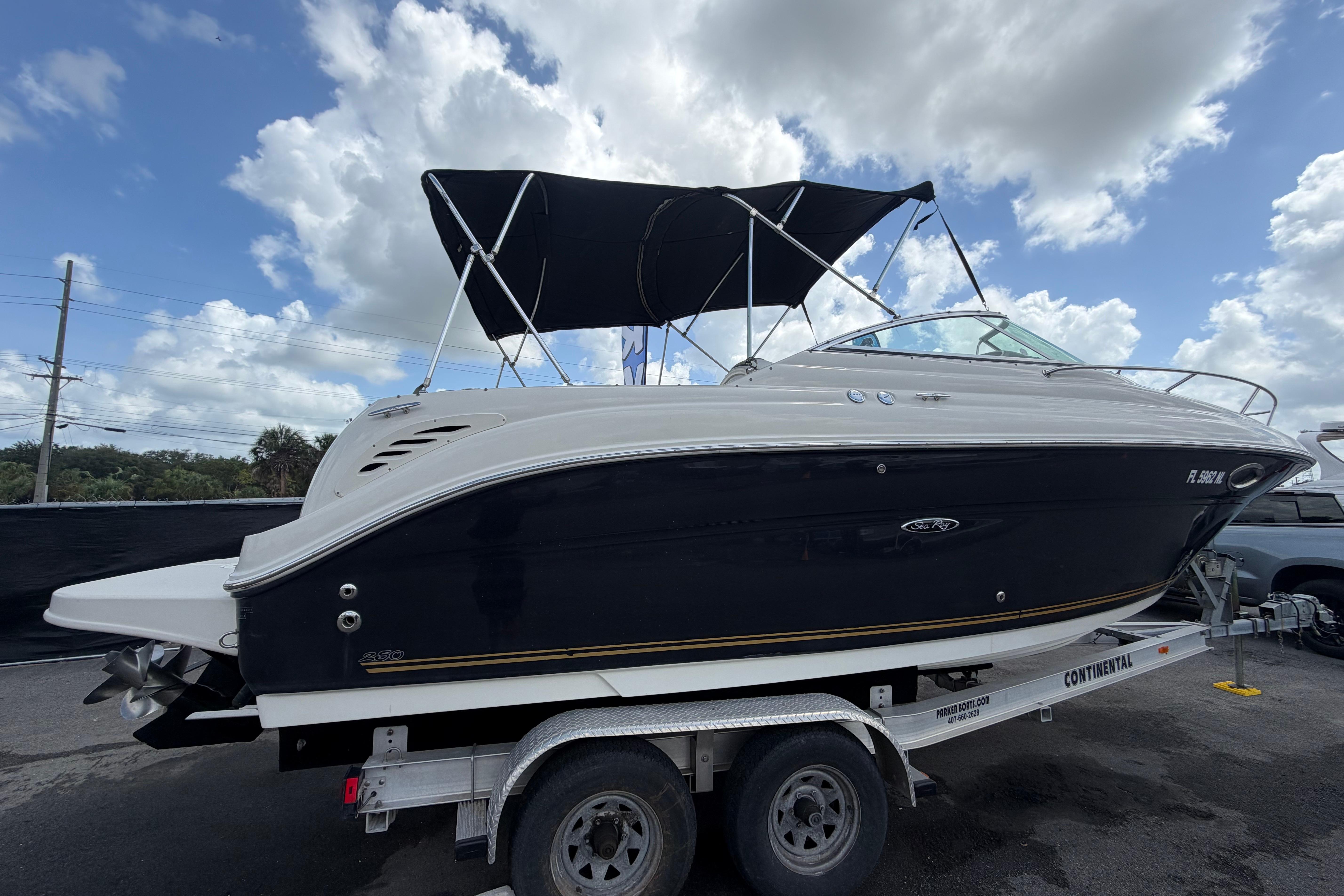 2006 Sea Ray 250 Amberjack boat on trailer under cloudy sky.