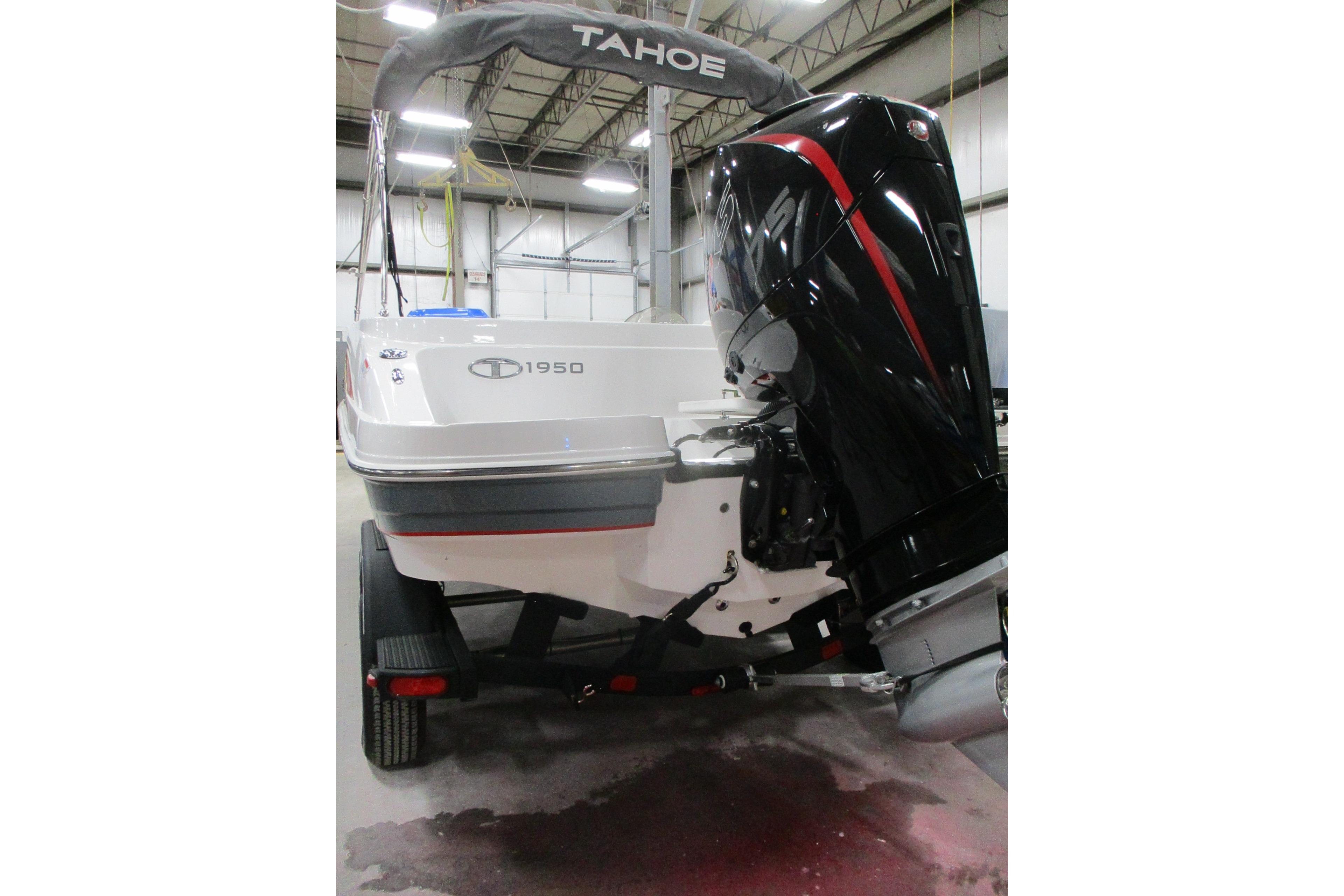 2024 Tahoe 1950 boat with outboard motor in a warehouse setting.