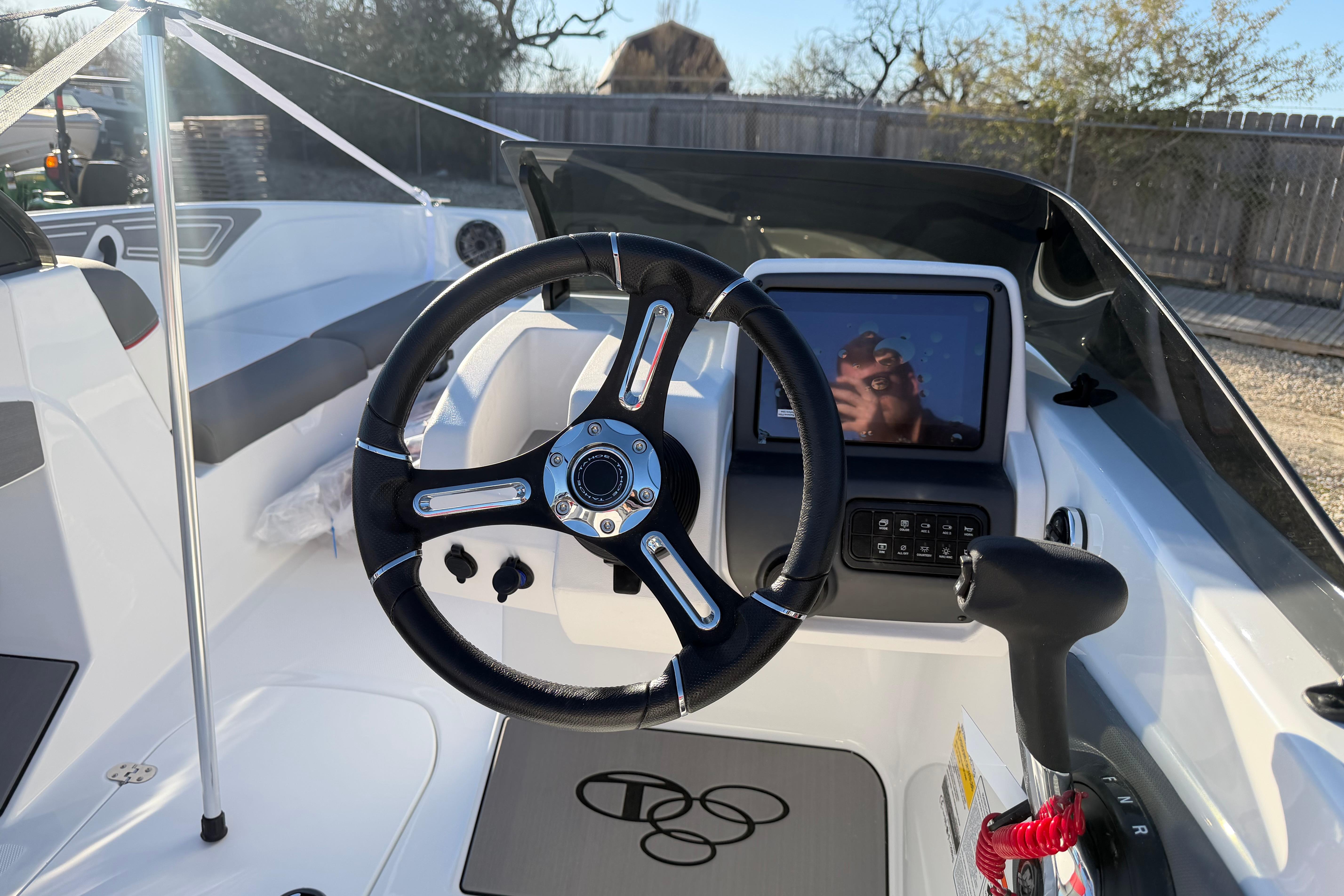 Steering wheel and dashboard of 2026 Tahoe T21 boat, featuring modern controls and touchscreen display.