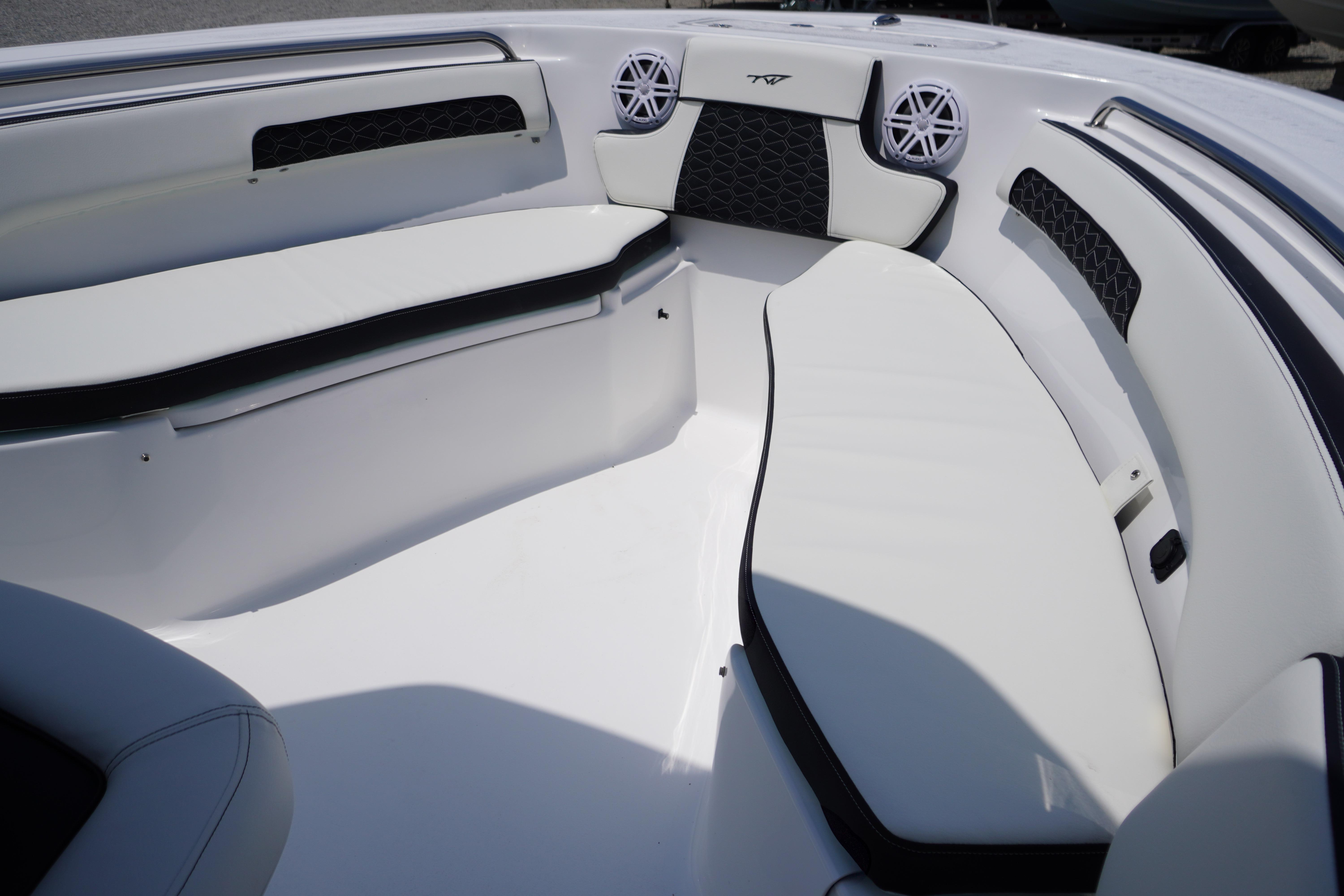 2027 Tidewater 220 CC Adventure boat interior with white cushioned seating and speakers.