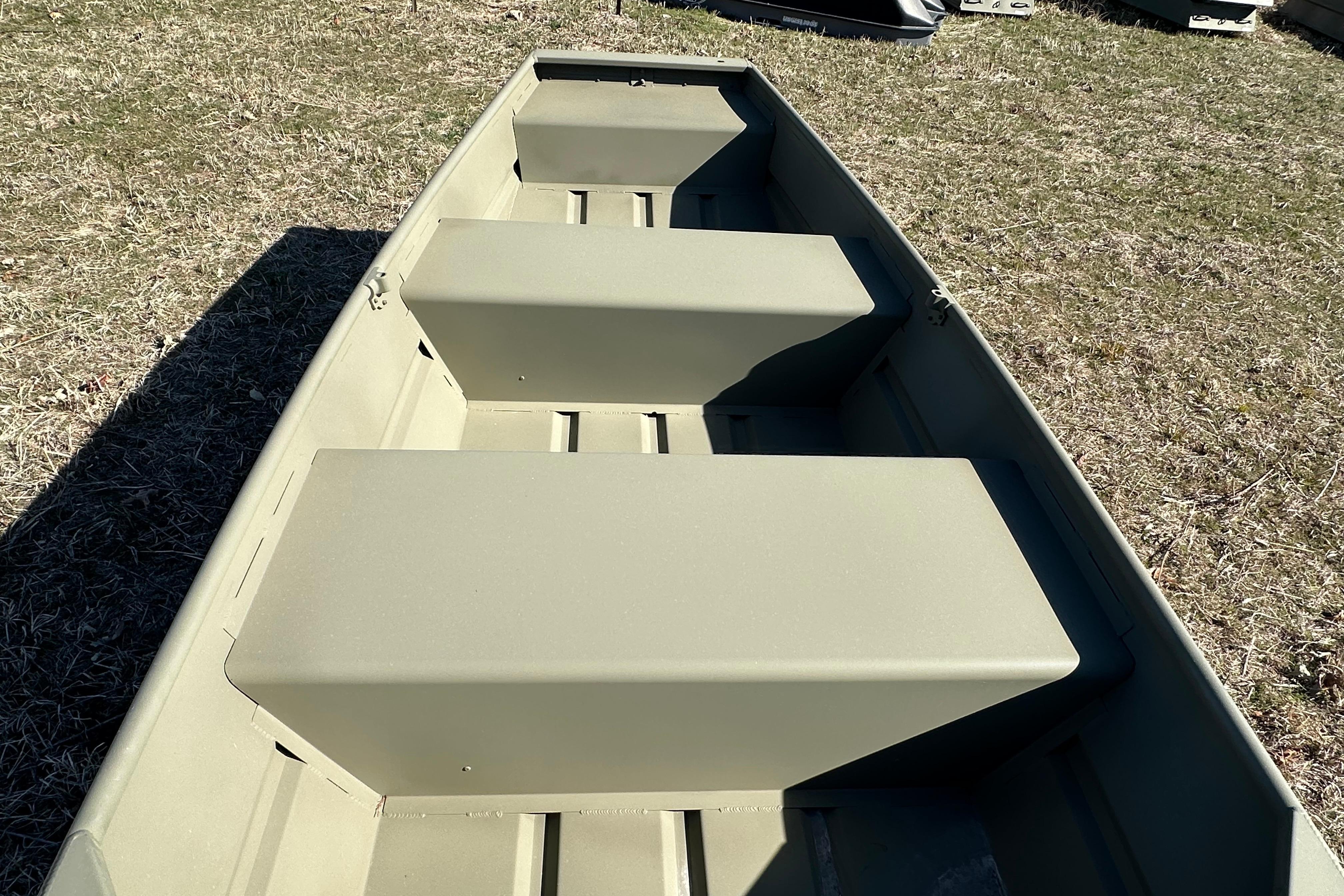 2026 Tracker Grizzly 10 Jon boat interior with bench seats on grass.