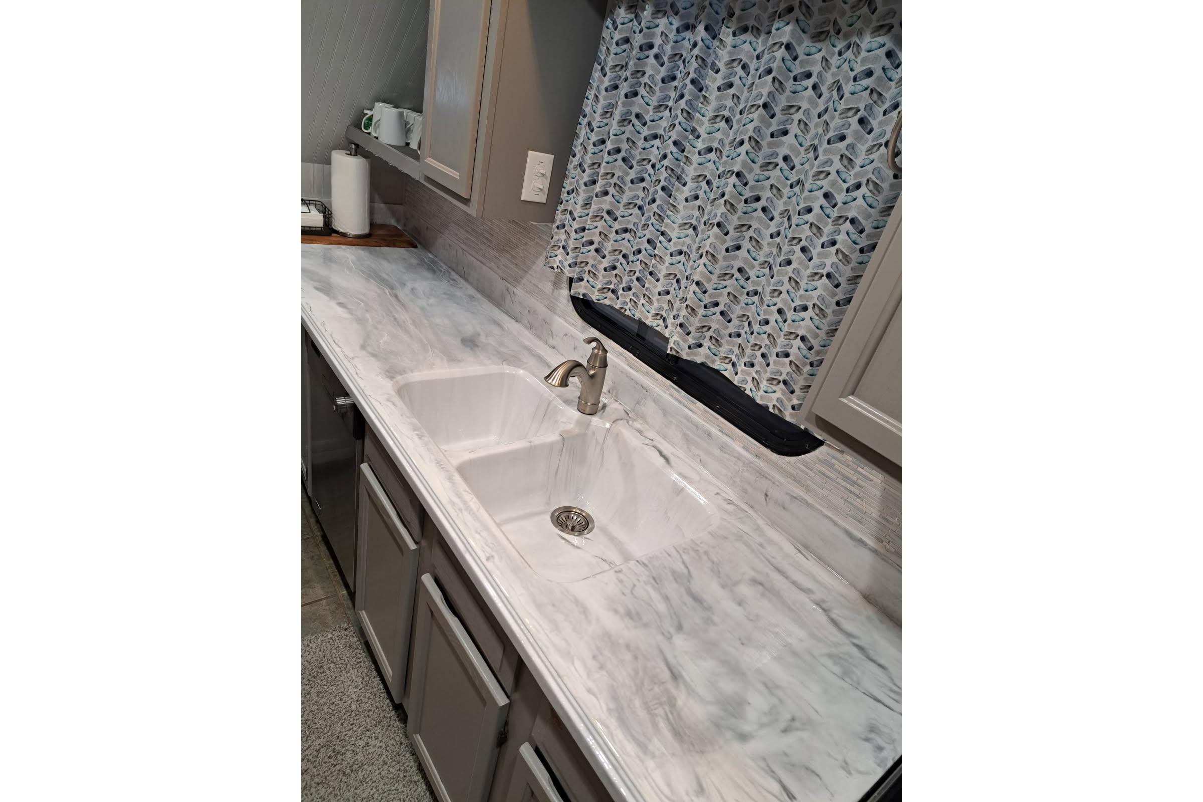 Marble countertop with sink in 1990 Sumerset 16 x 70 houseboat kitchen.