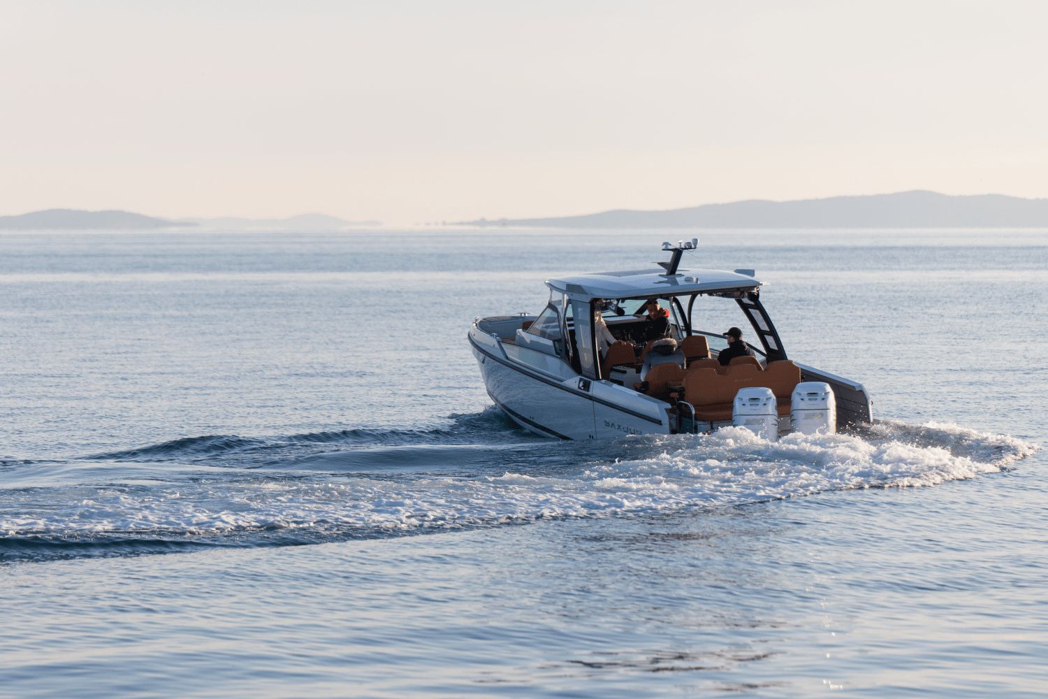 A Saxdor SX320 GTO boat cruising on calm water with two outboard engines.