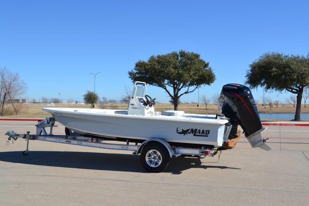 2026 Mako 18 Pro Skiff boat on trailer, parked outdoors under clear blue sky.