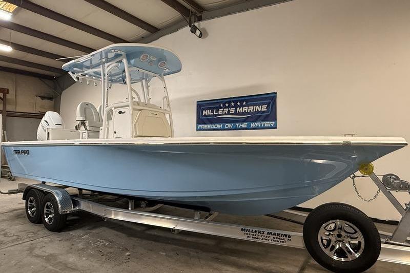 2026 Sea Pro 250 Bay boat in showroom, light blue hull, on trailer at Miller's Marine.