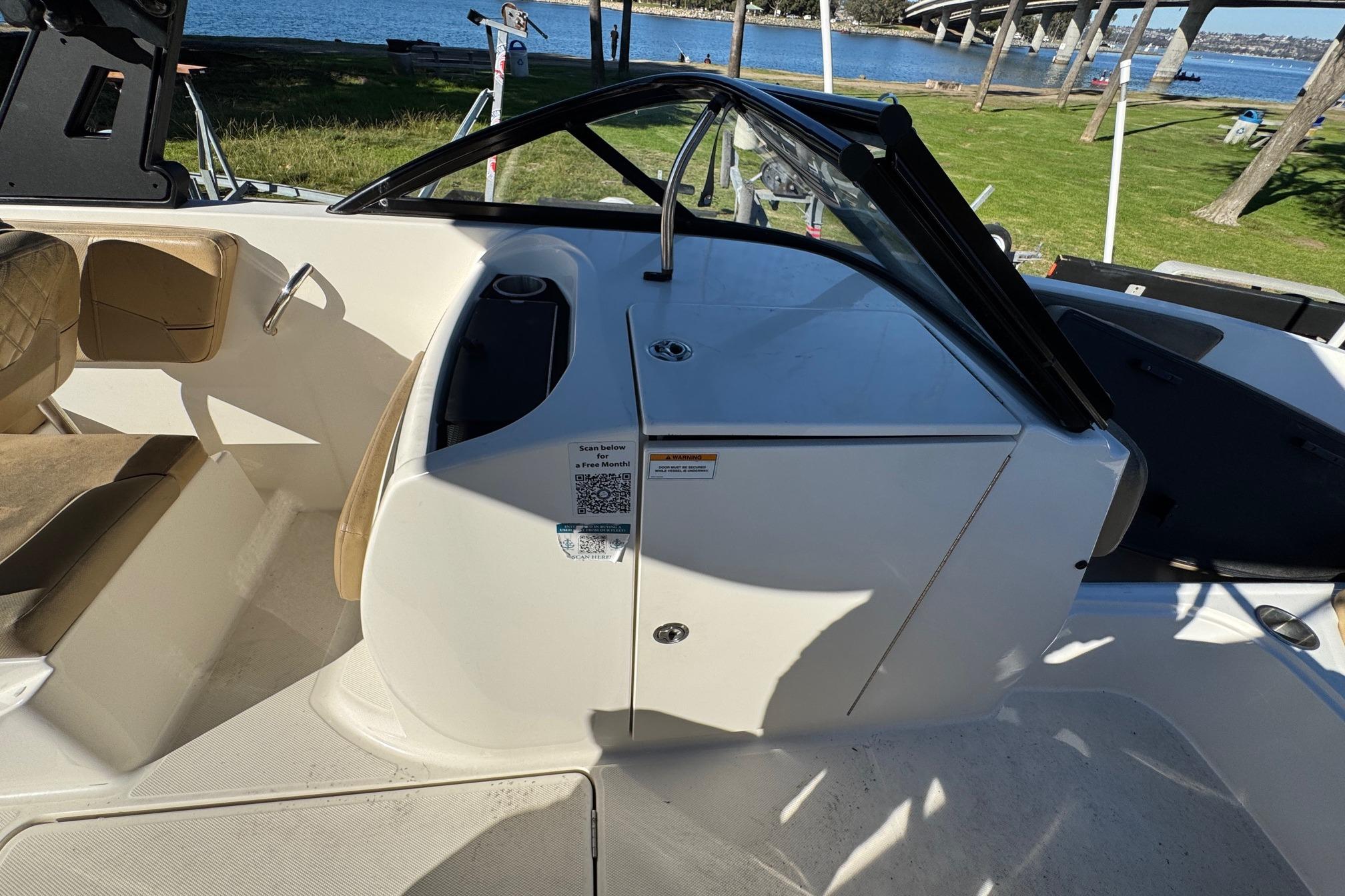 2022 Bayliner VR6 Bowrider OB interior with seating and console, near a waterfront.