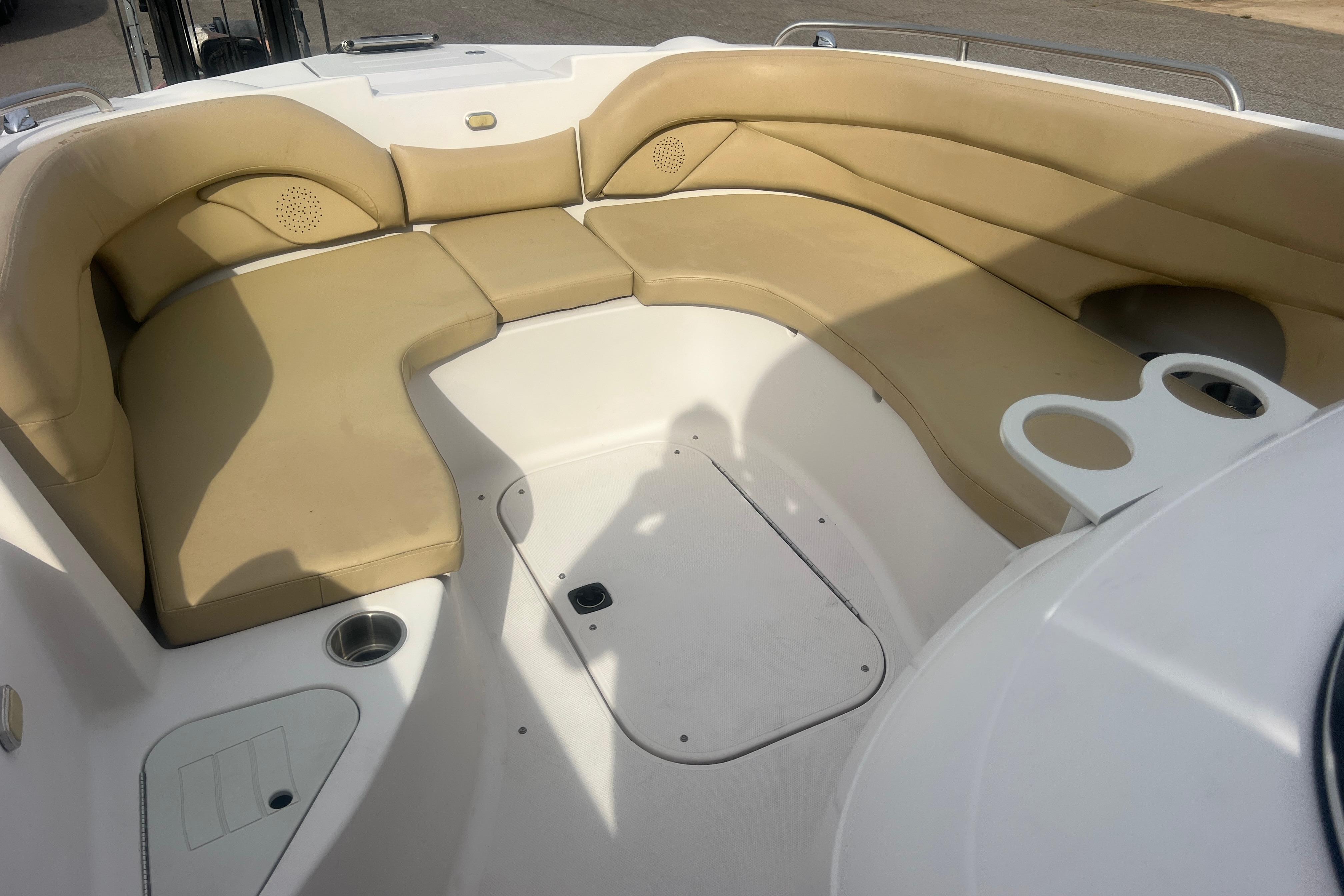 2002 Hurricane SunDeck 260 OB boat interior with beige seating and cup holders.