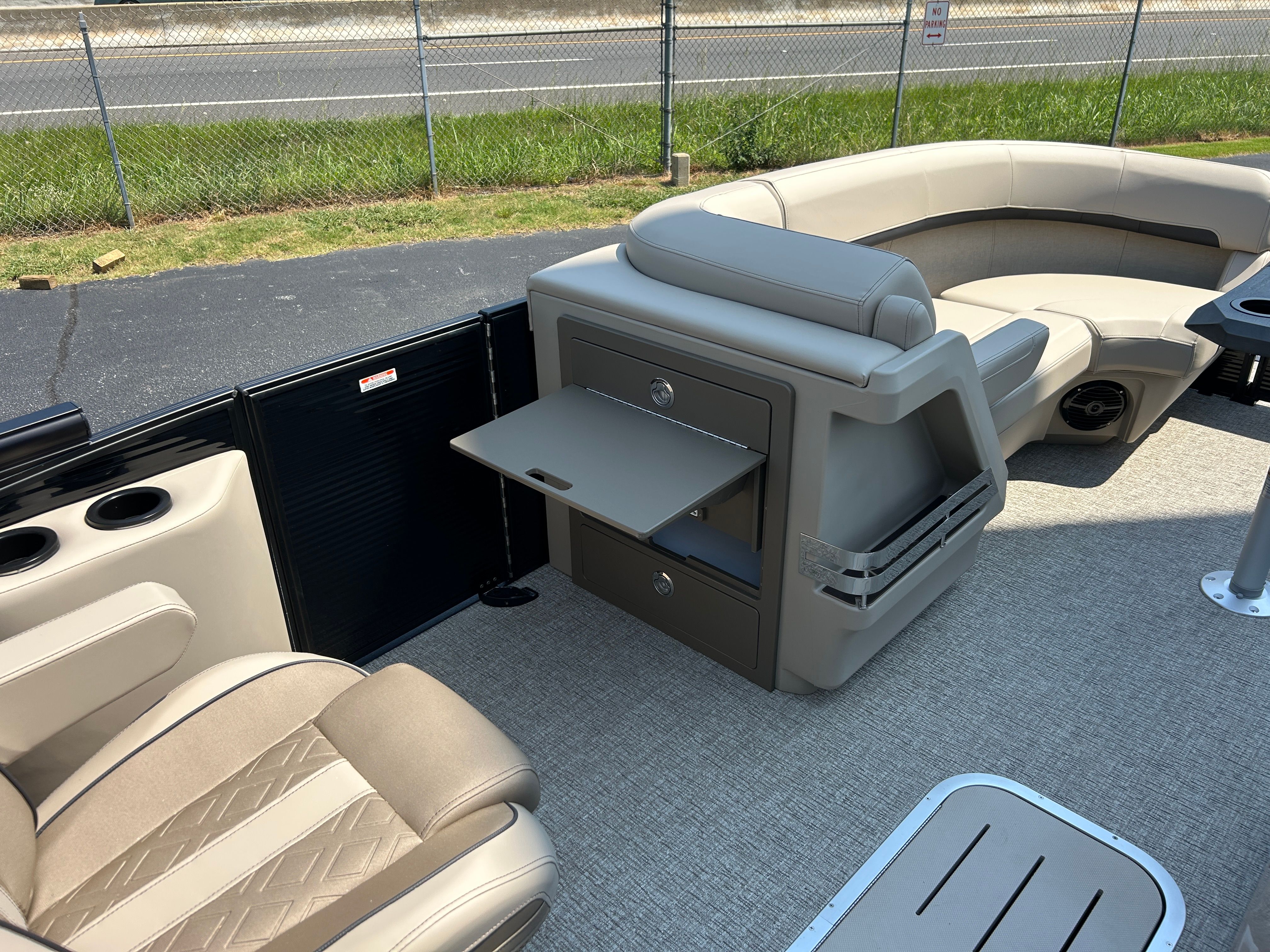 The image shows the interior of a Bennington 22 MFB pontoon boat with beige seating and a fold-out table.