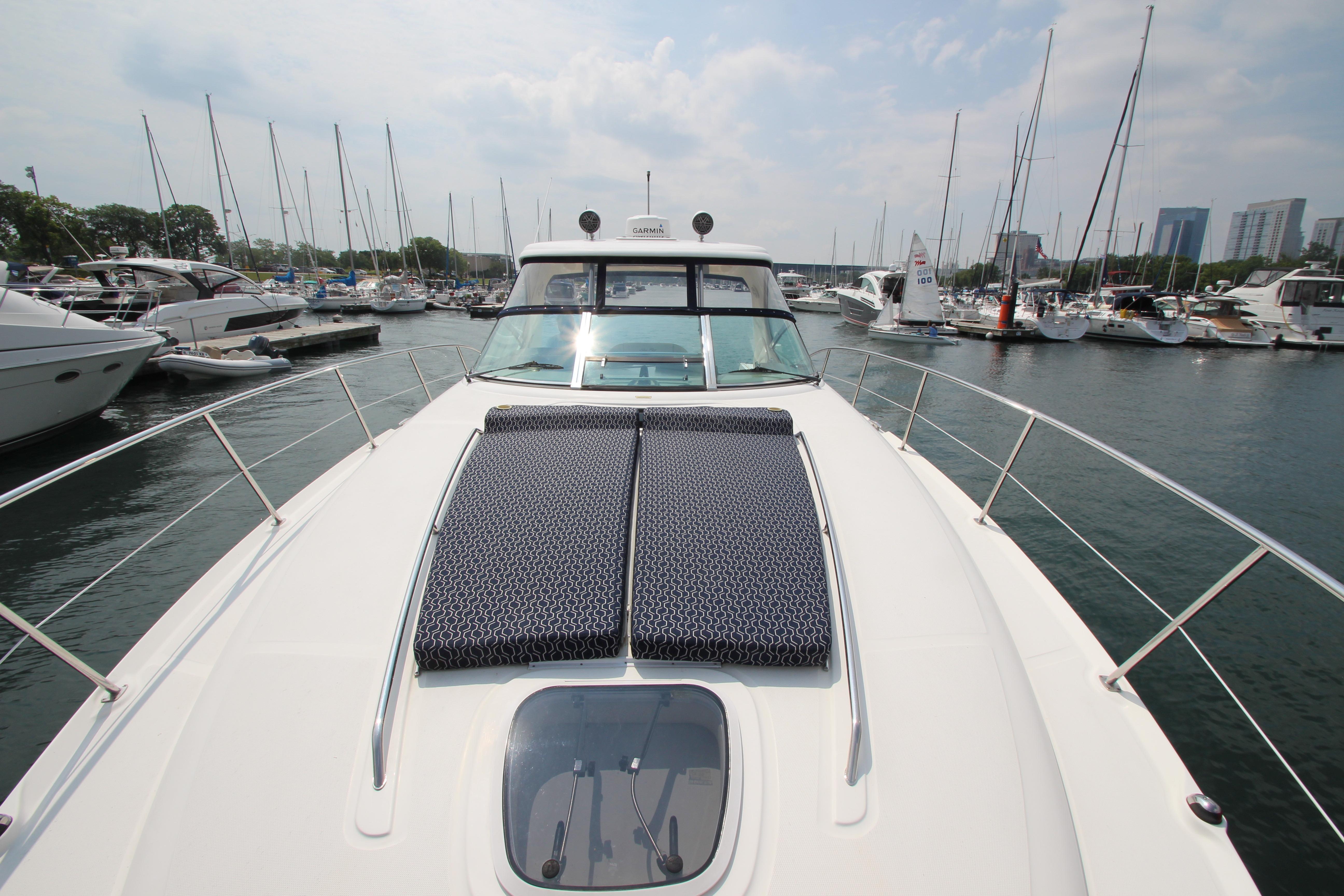 2004 Sea Ray 40 Sundancer yacht docked in a marina with city skyline.