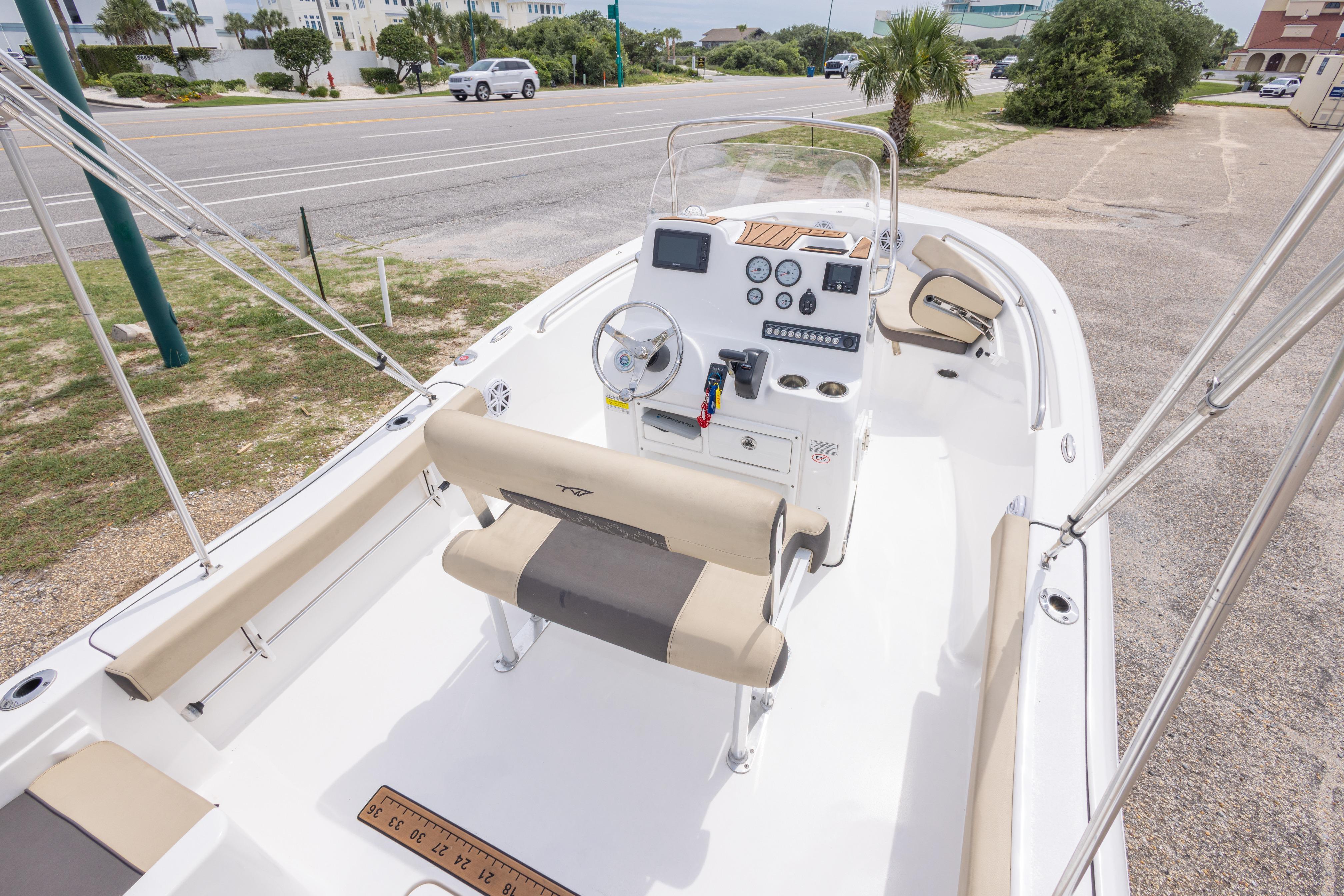 2021 Tidewater 198 CC Adventure boat interior with console and seating, parked near a road.