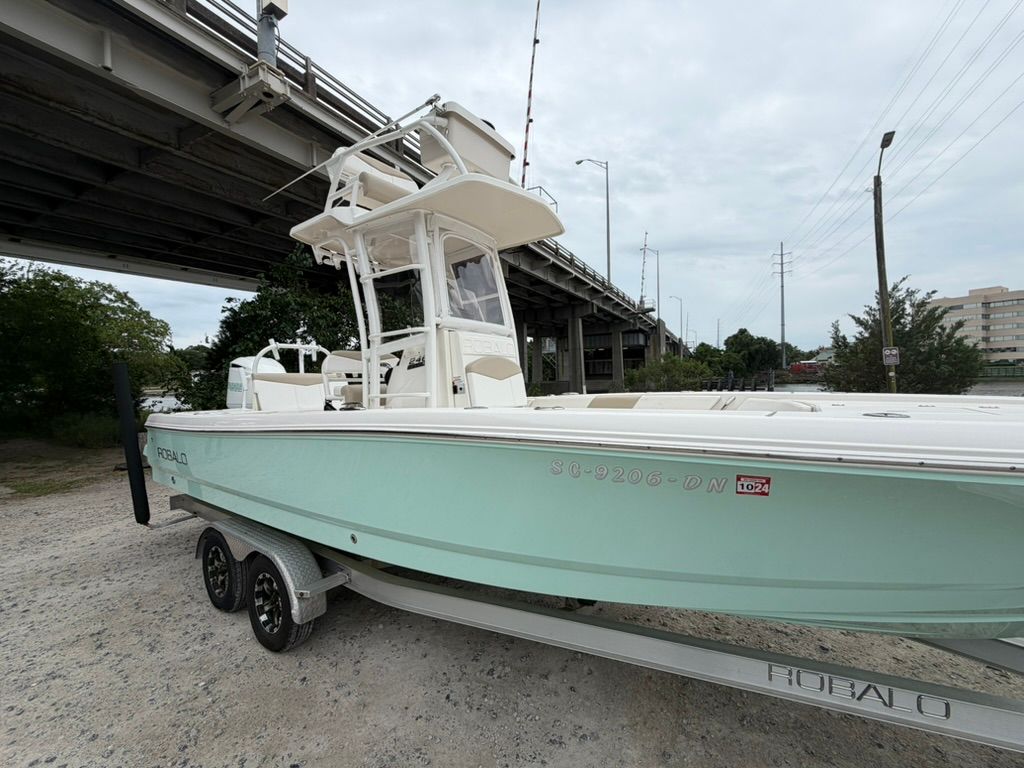 2018 Robalo 246 Cayman SD boat on trailer under bridge.