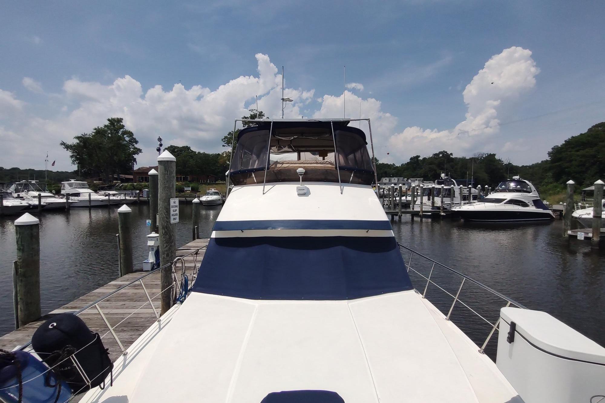 1989 Hyatt Double Cabin Motoryacht docked at a marina under a clear blue sky.