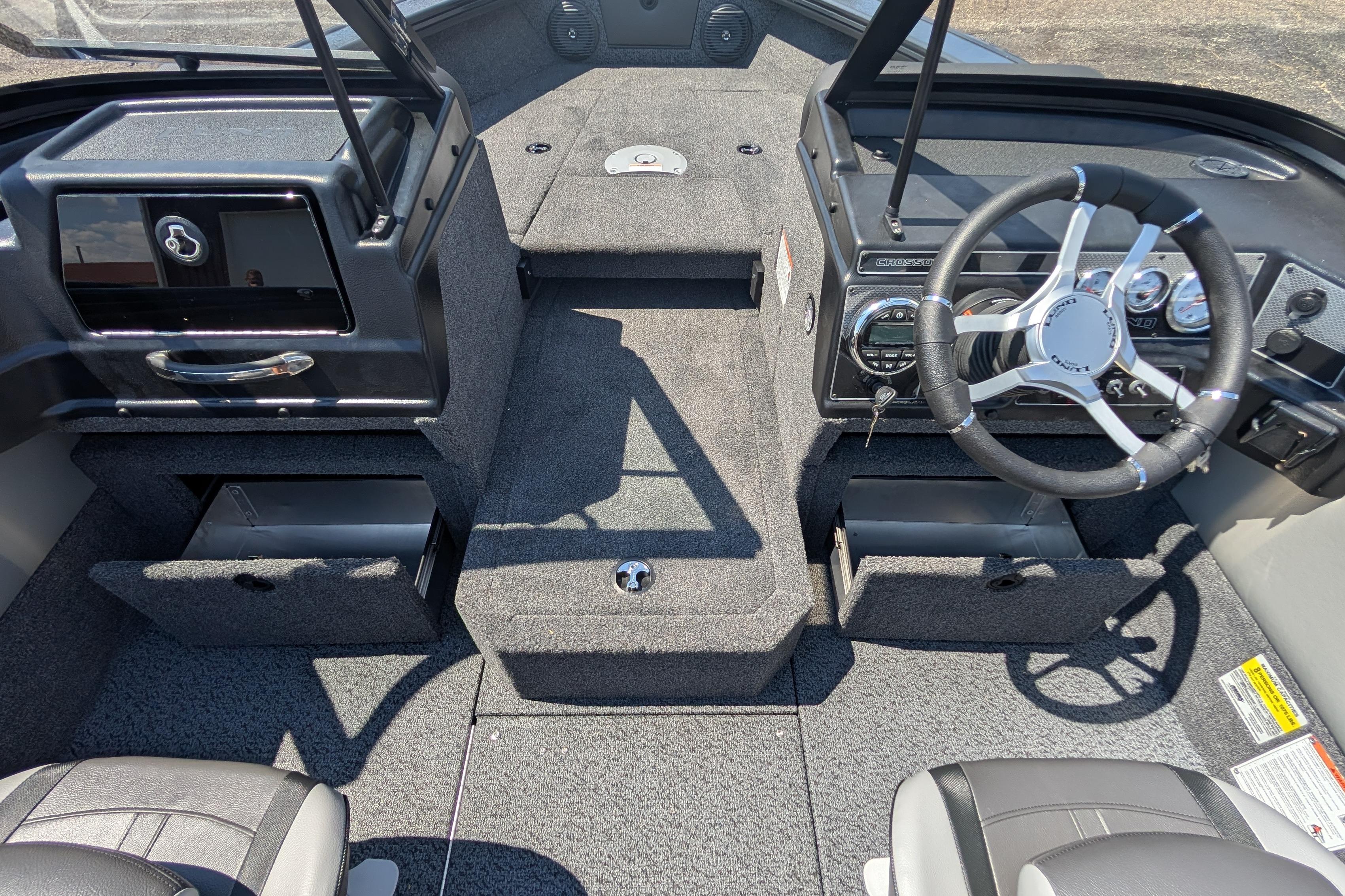 2026 Lund 1875 Crossover XS boat interior with steering wheel and storage compartments.