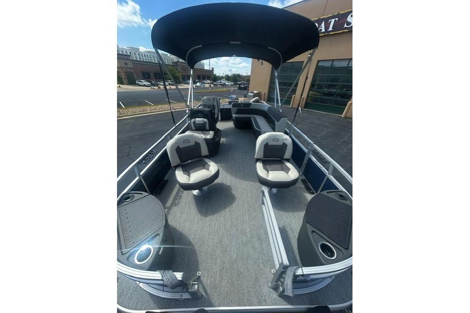 2026 Sun Tracker Bass Buggy 18 DLX pontoon boat with seating and canopy, parked outdoors.