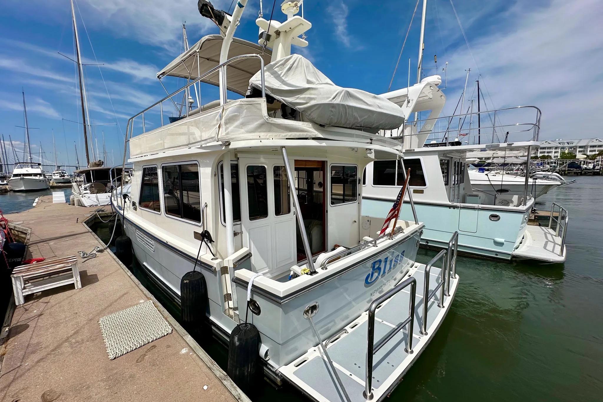 2016 Helmsman Trawlers 38 Pilothouse docked at marina under clear blue sky.