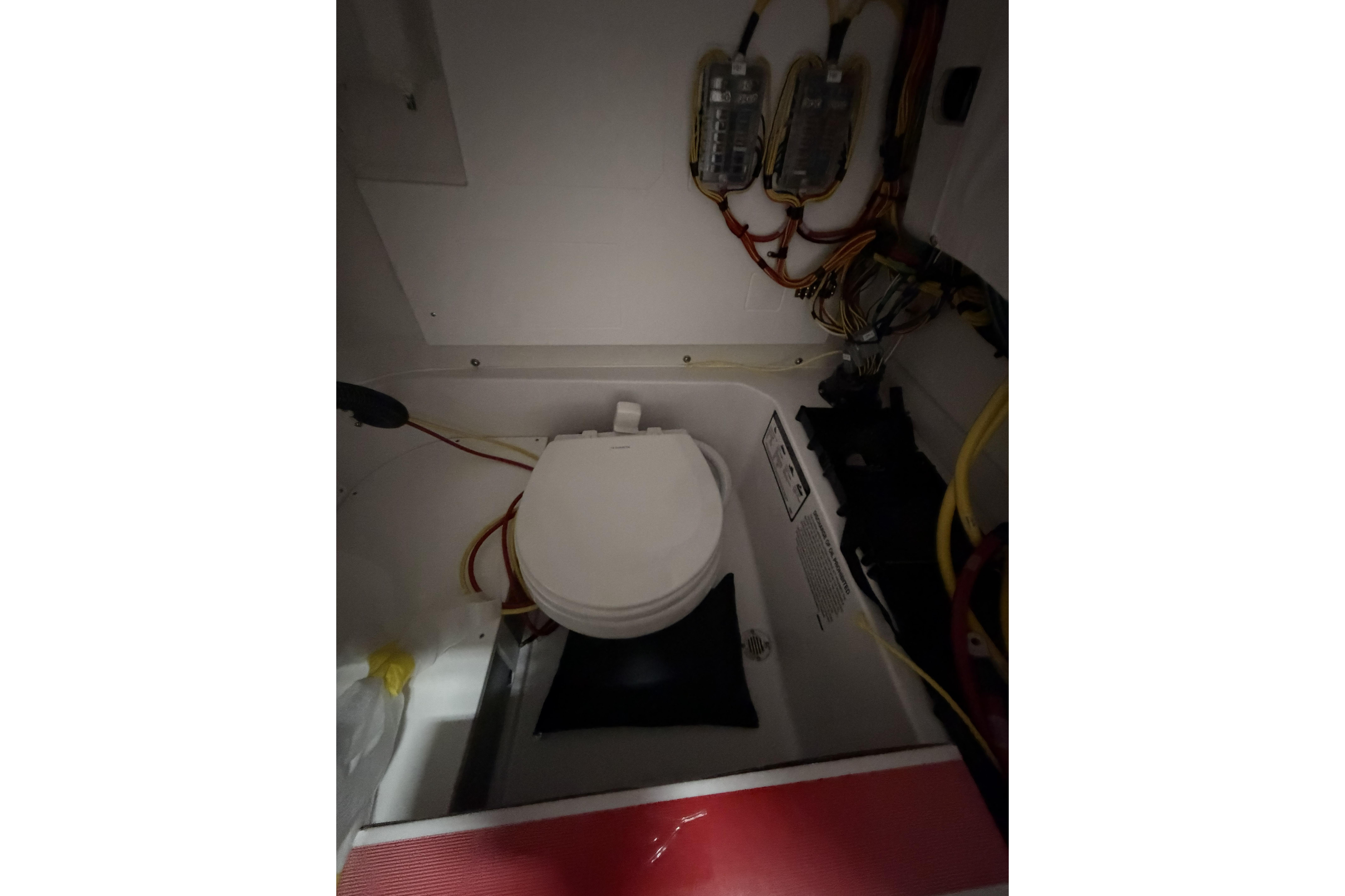 Interior of 2026 Sportsman Open 232 Center Console boat, featuring a compact marine toilet.