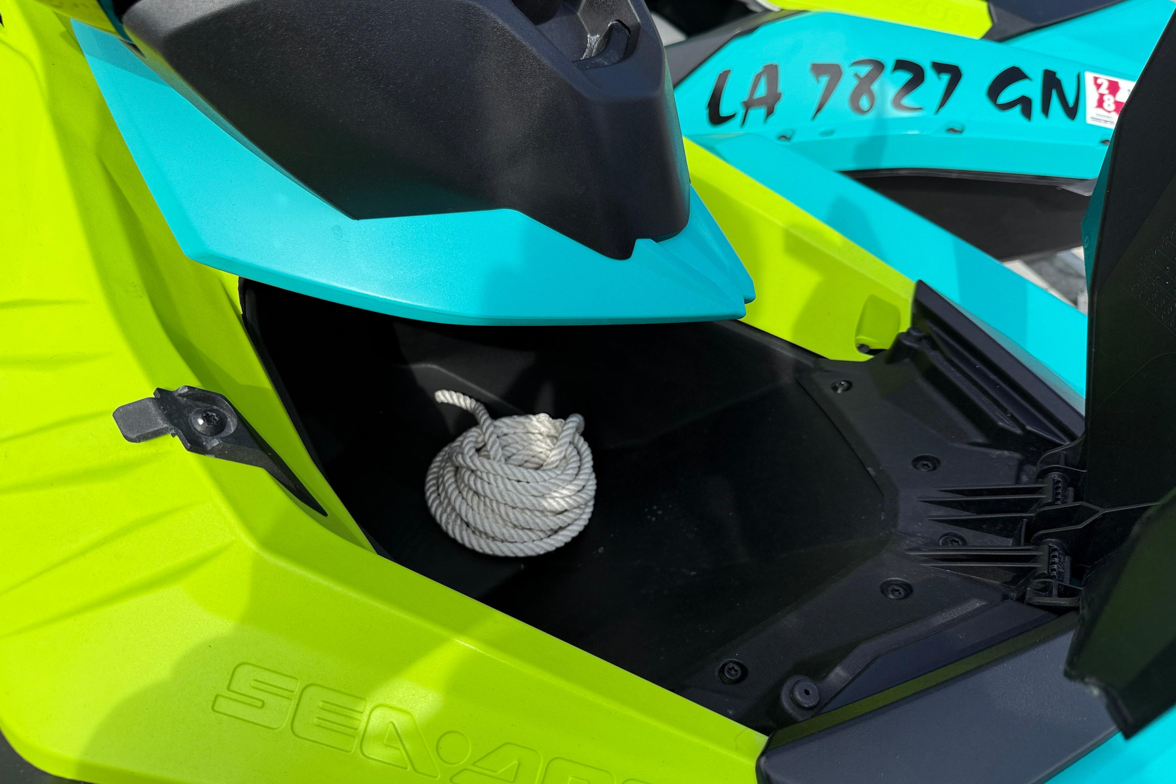2022 Sea-Doo Spark 3up storage compartment with rope, vibrant yellow and blue design.