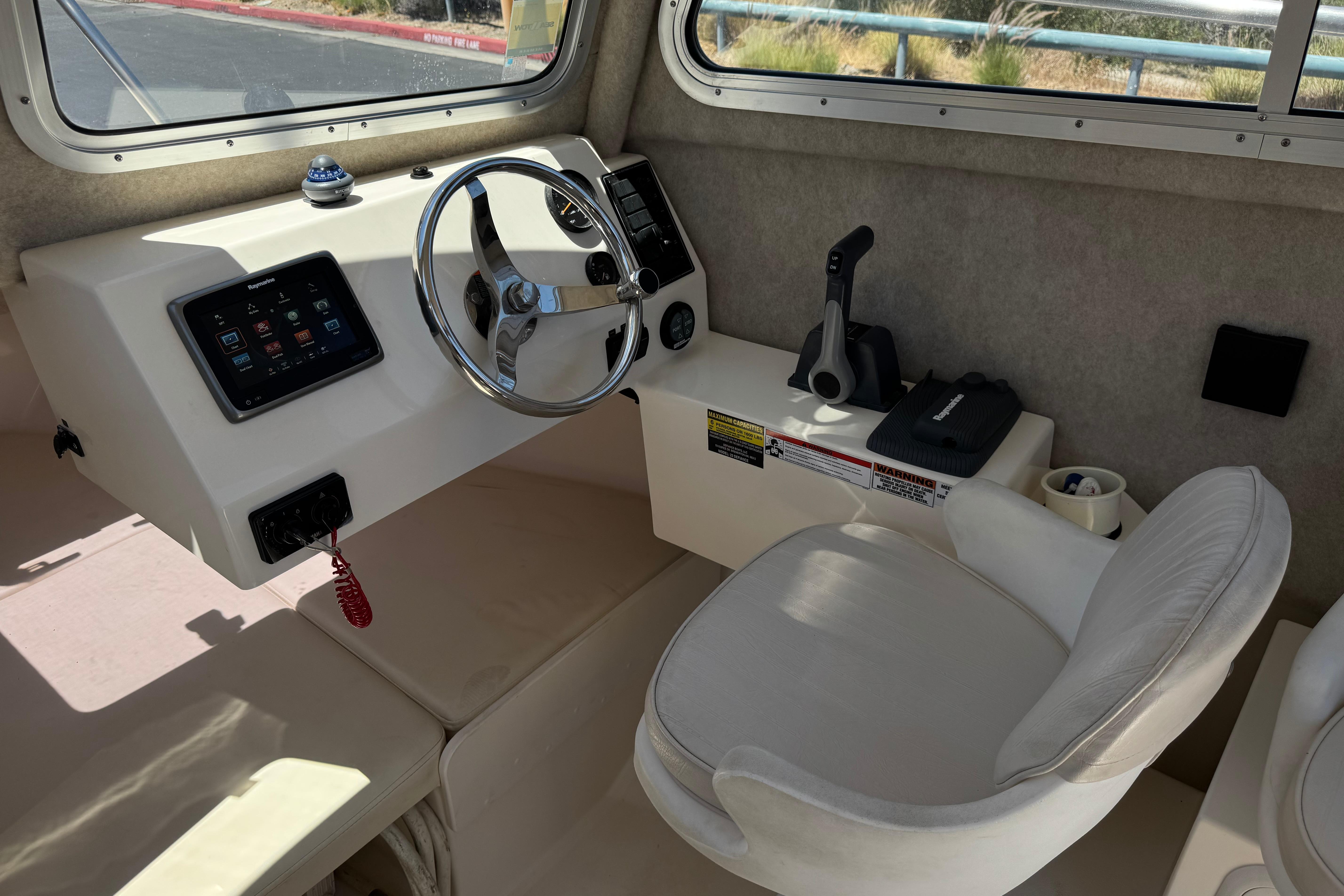 2017 Defiance Admiral 220 EX boat cockpit with steering wheel and control panel.