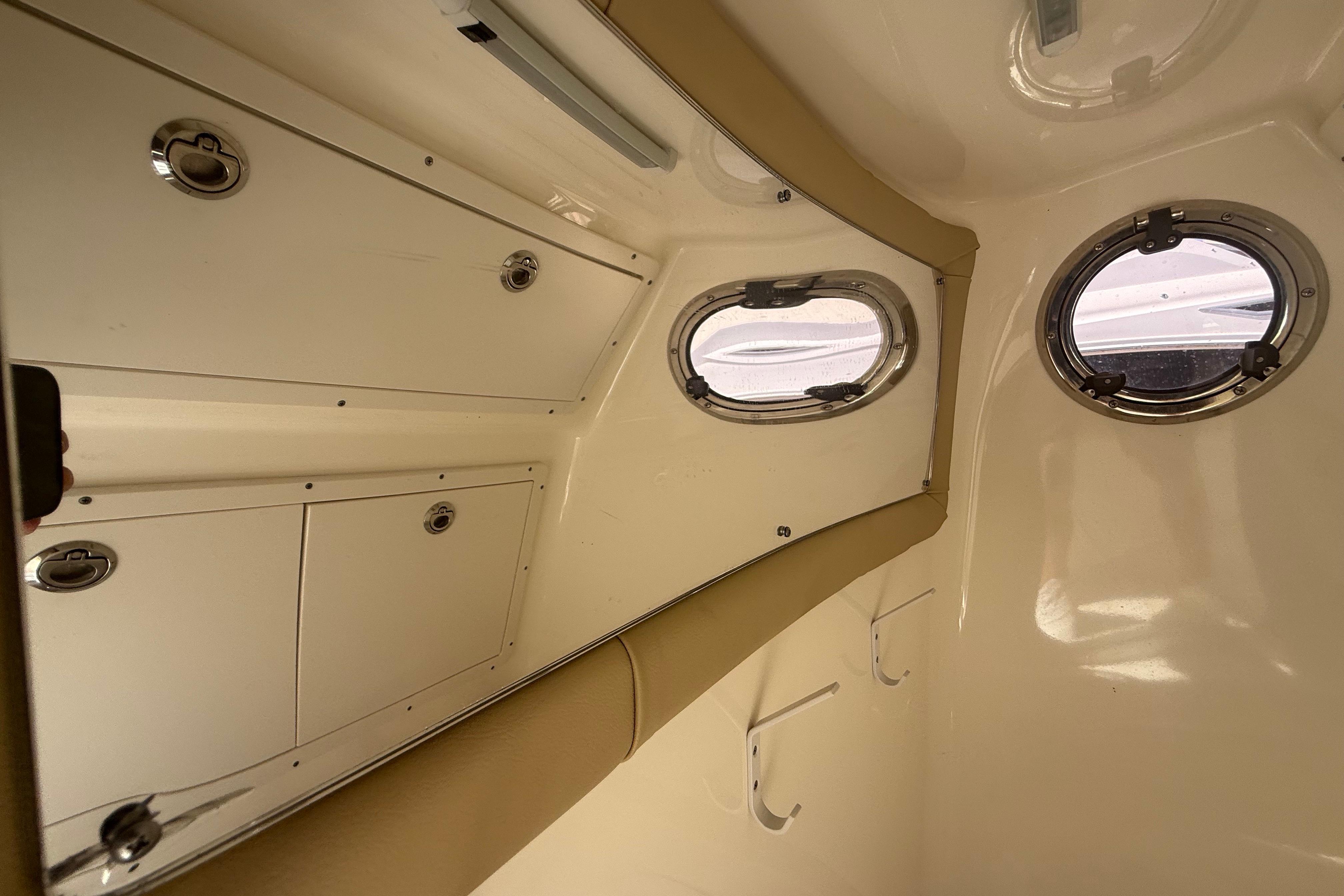 Interior cabin of 2019 Key West Billistic 281 Center Console boat with portholes and storage.