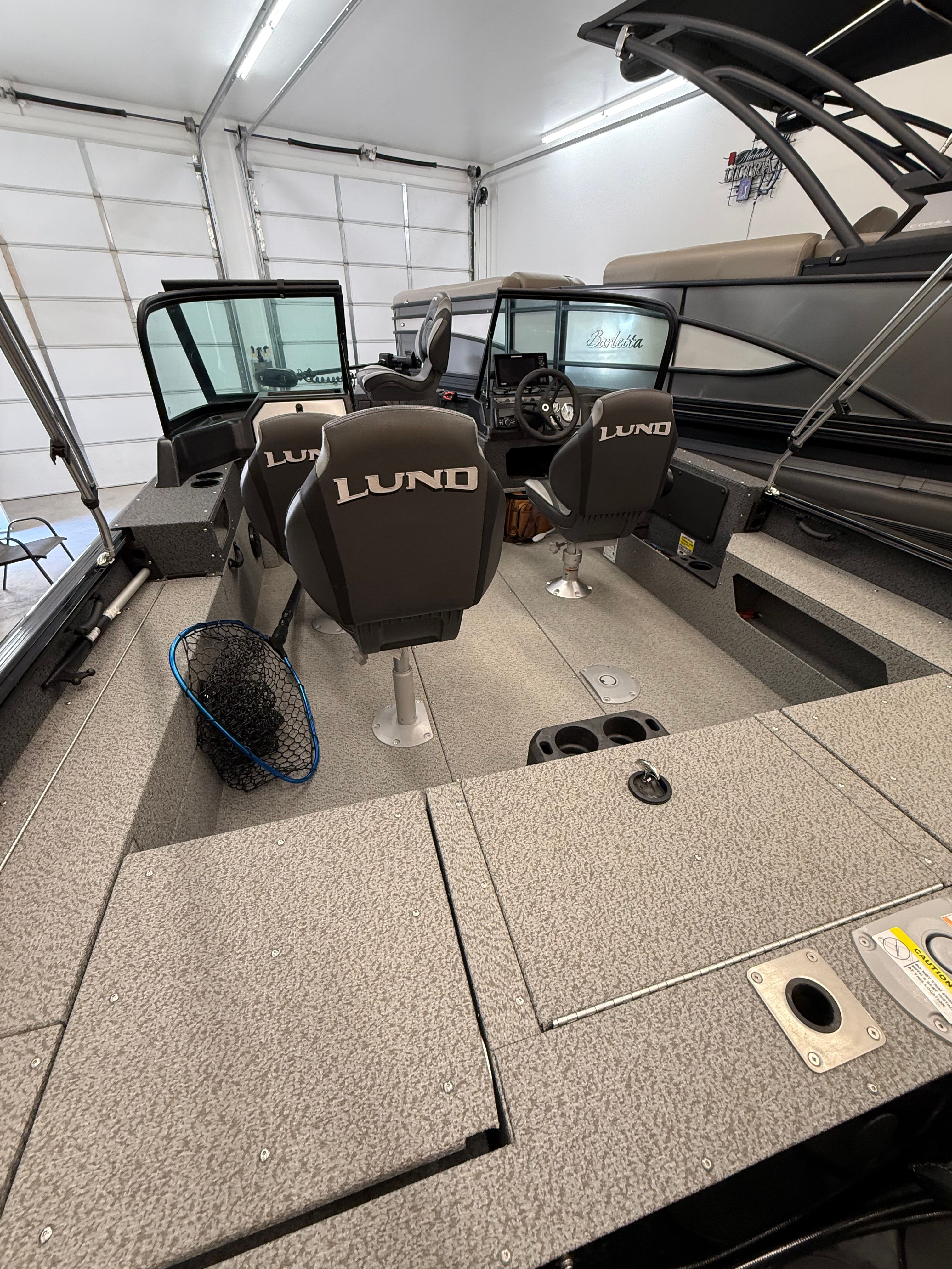 Interior view of a Lund 1875 Impact XS Sport boat with two seats and a helm console.