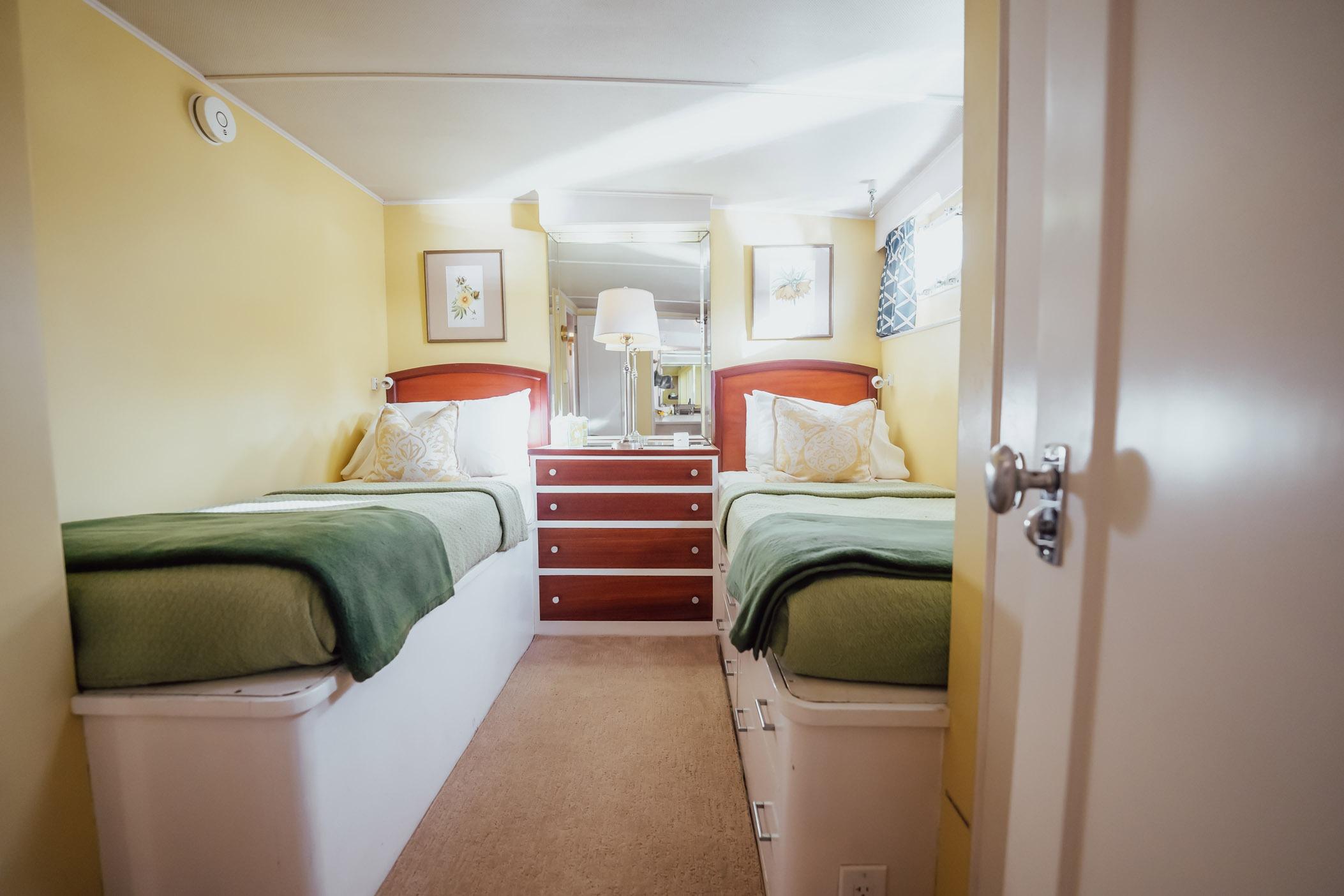 Interior of 1972 Trumpy 72 Motor Yacht with twin beds and cozy decor.