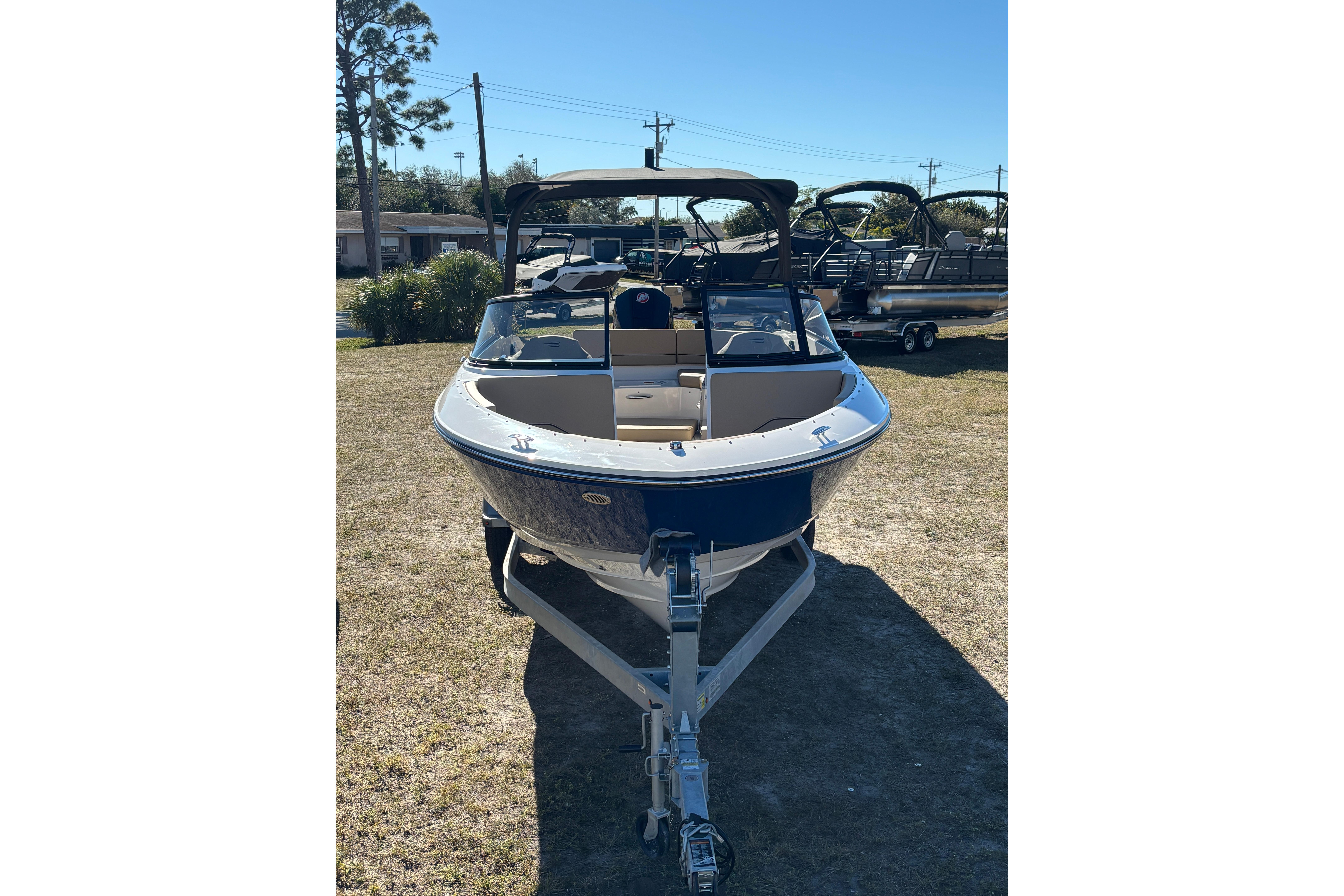 2025 Bayliner V20 boat on trailer, parked outdoors on grass.