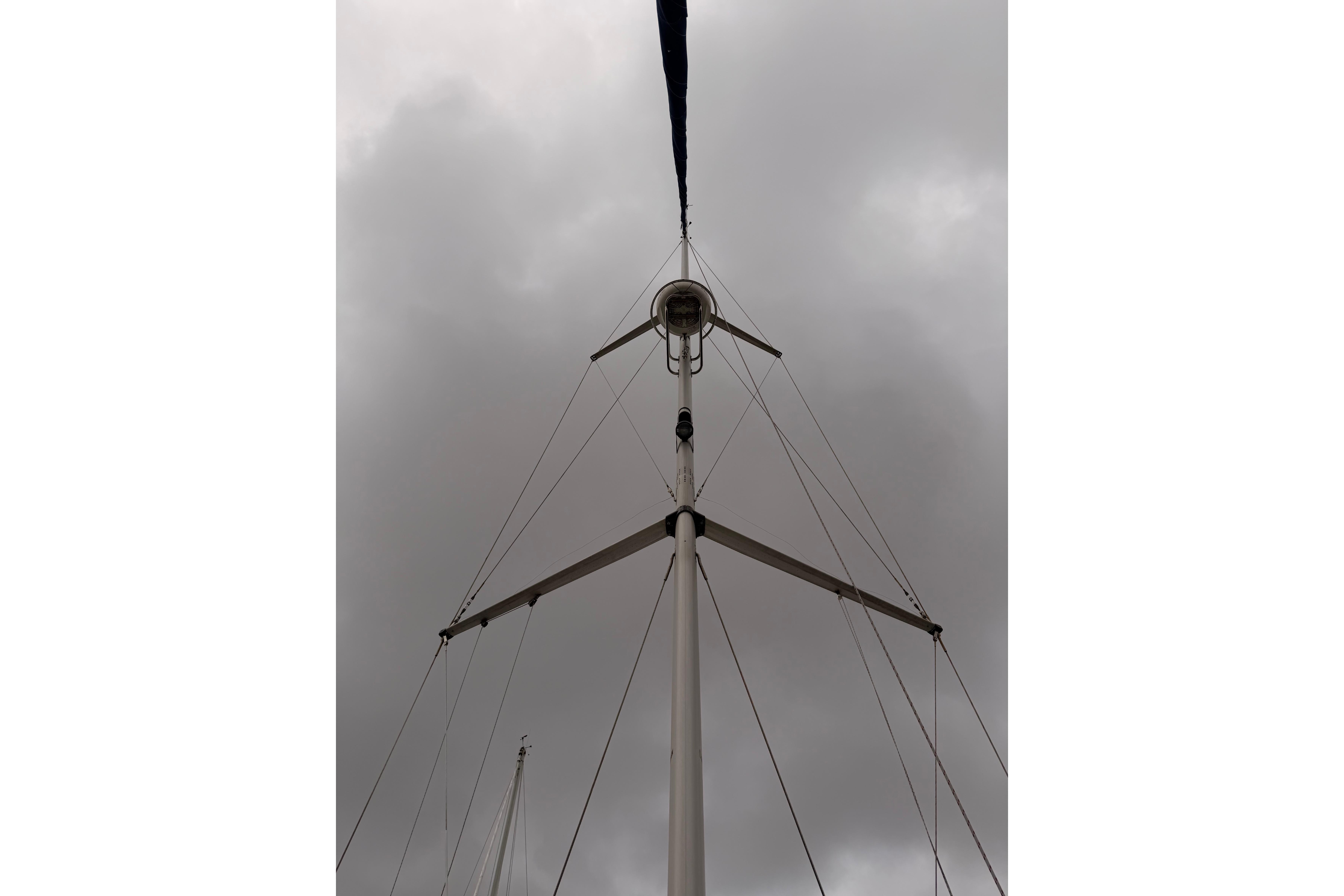 Mast of 2009 Hunter 38 sailboat against cloudy sky.