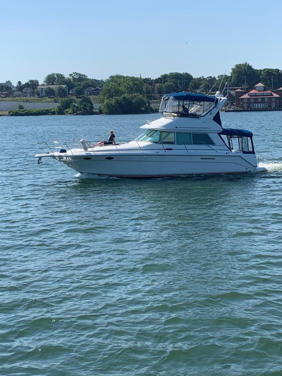 A white motorboat, Sea Ray 370 Sedan Bridge, cruising on calm water.