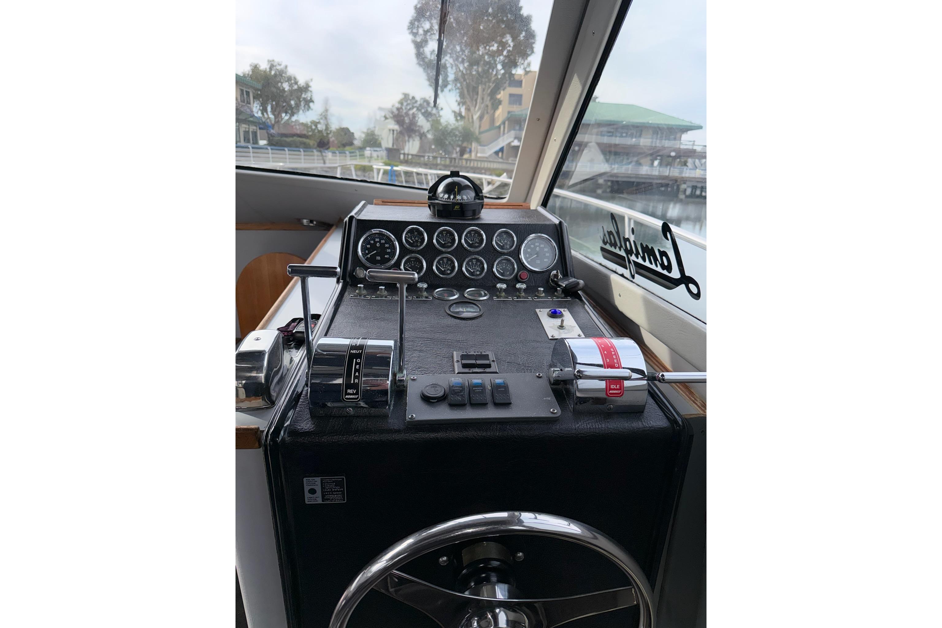 Cockpit of a 1990 Mediterranean Sport Fish boat with control panel and steering wheel.