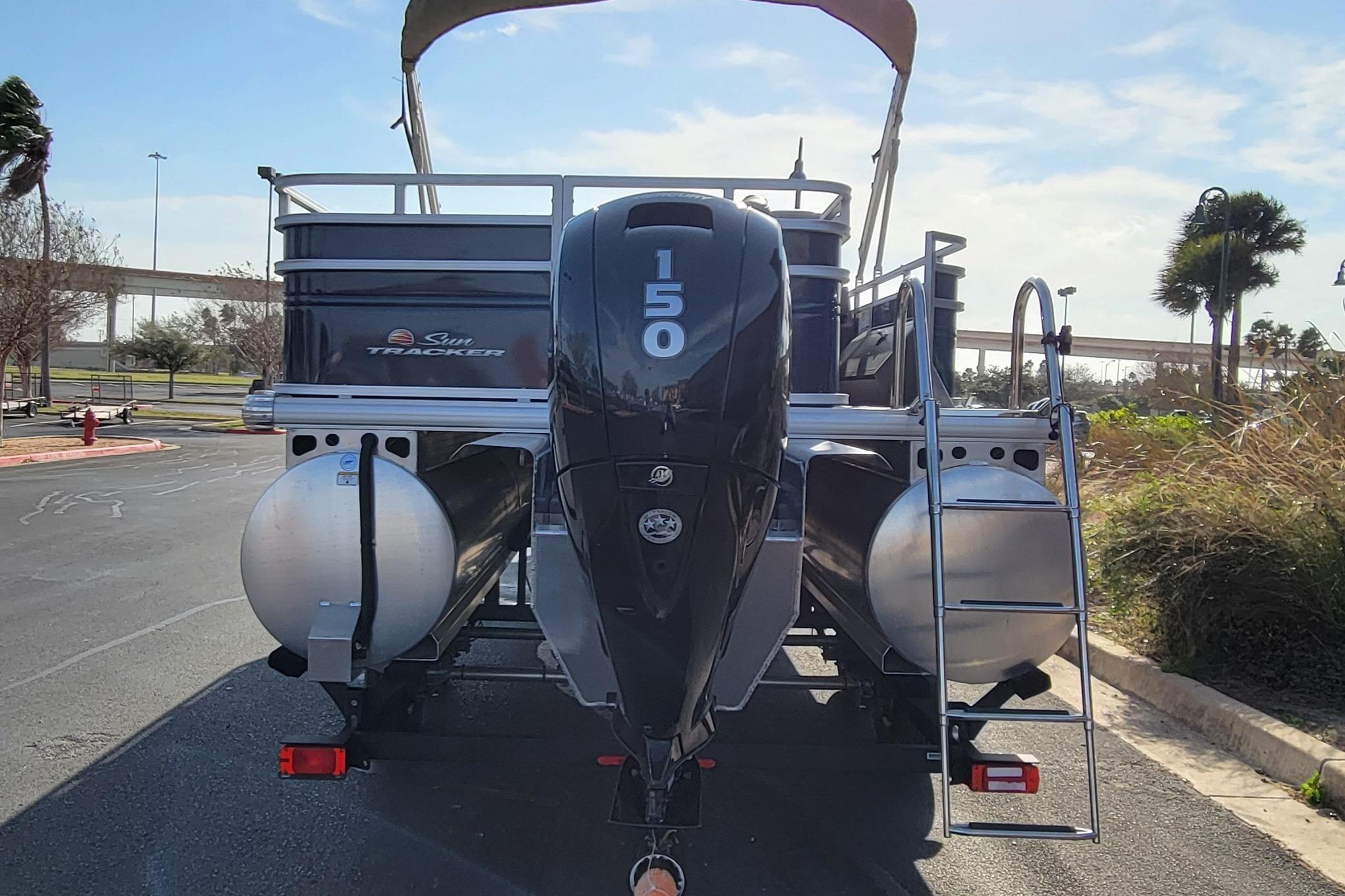 2025 Sun Tracker Fishin' Barge 22 XP3 pontoon boat with 150 HP engine, rear view.